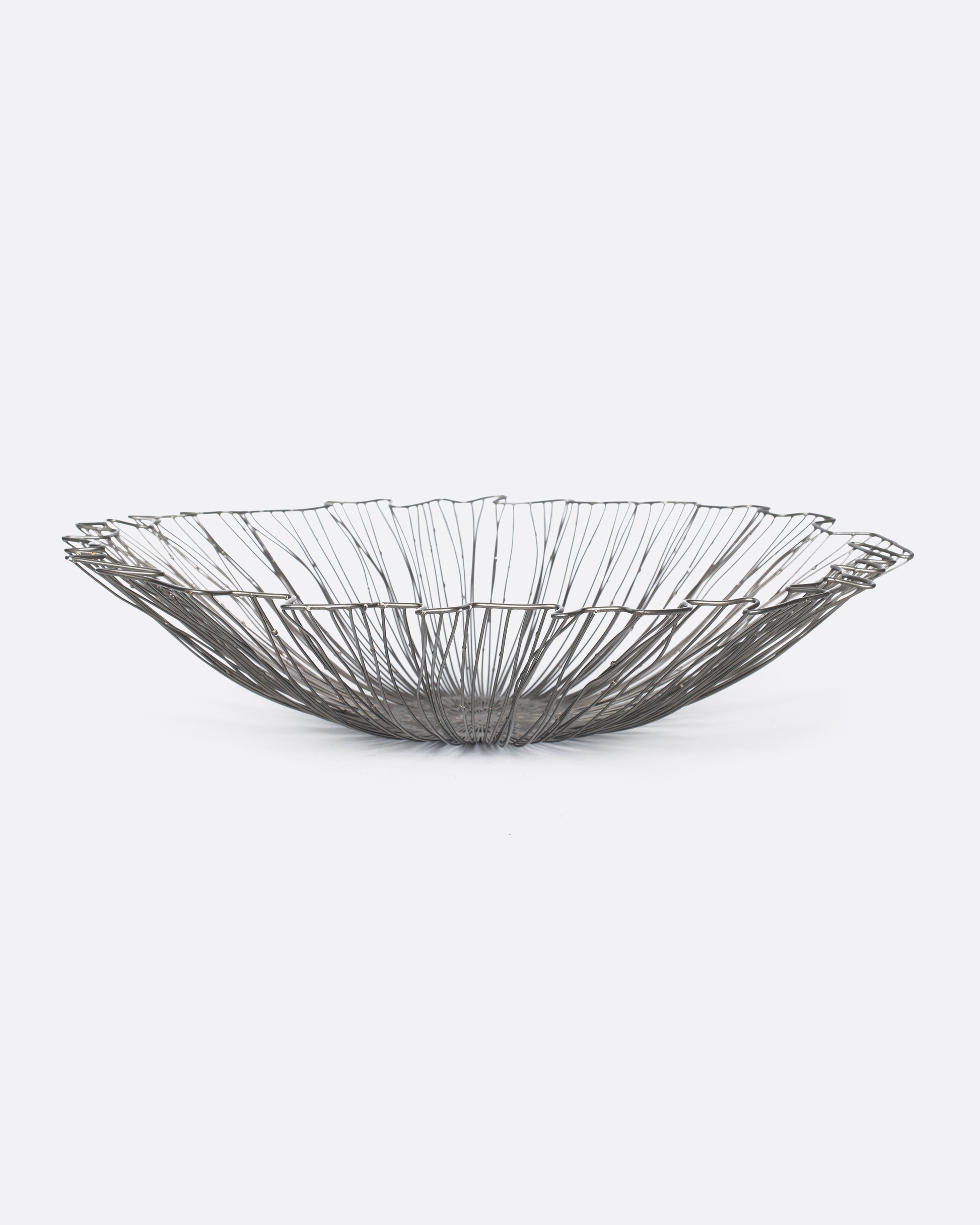 A wide, rippled wire bowl that's the perfect centerpiece for a kitchen island or dinner table.