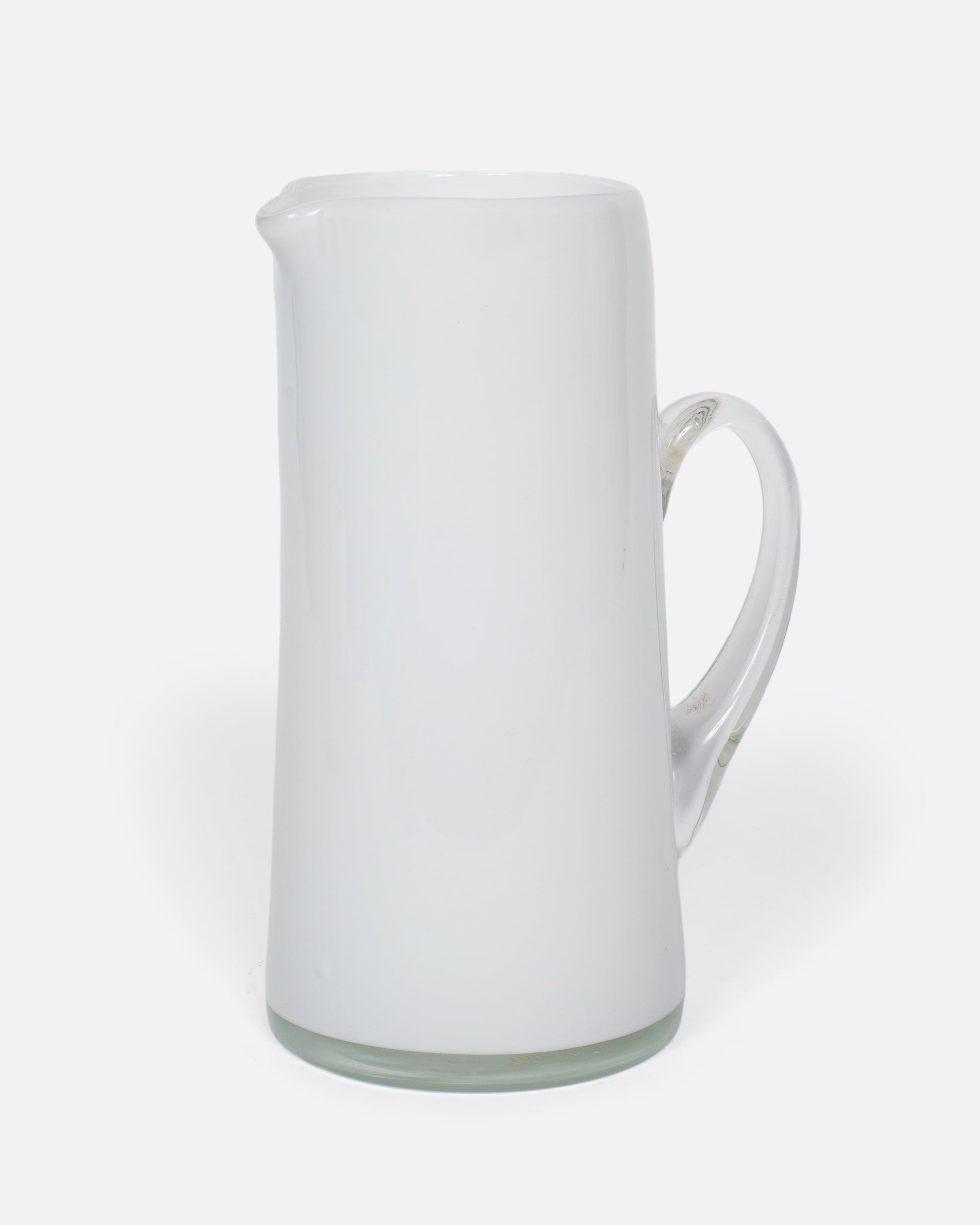 A vintage white cased glass pitcher. Two layers of white glass add depth to its color, creating an elegant, sleek look.