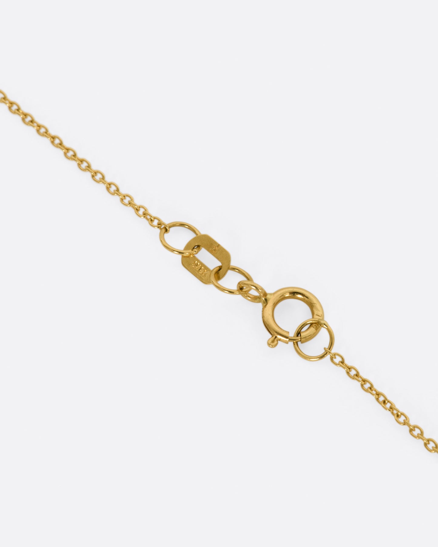 A yellow gold bar necklace with a single row of white diamonds. View of the clasp.