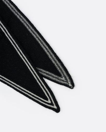 A close up of a cashmere black neck scarf with stripy white edges.