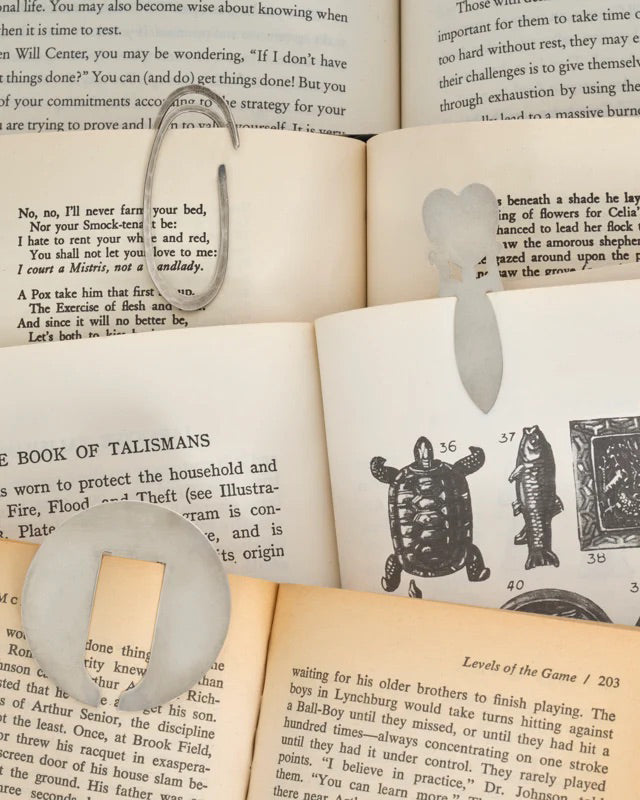 Three sterling bookmark resting on the pages of an open book.