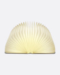 A book shaped light with a laser-cut wooden cover, shown open from the front.