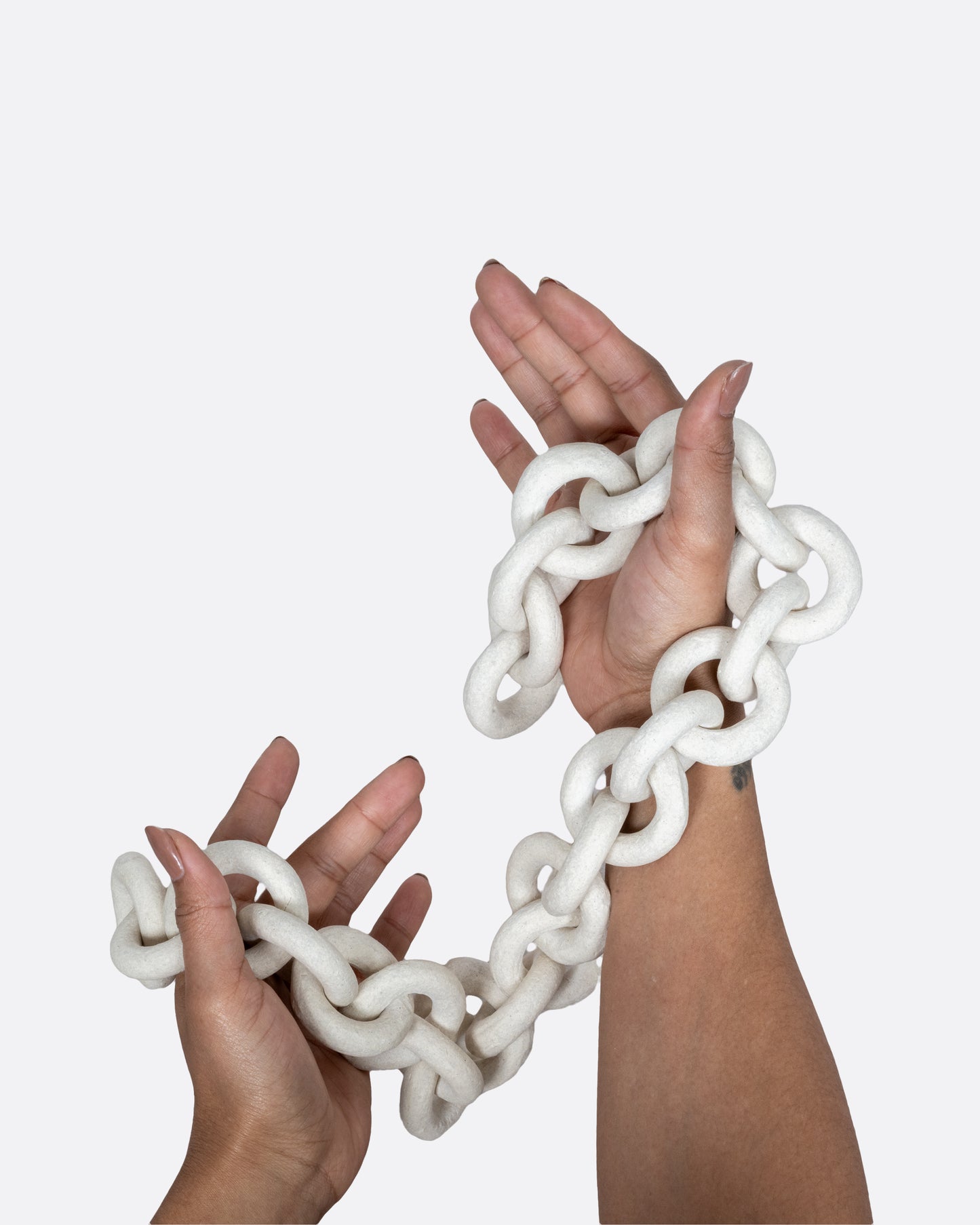 A white ceramic chain shown in hands.