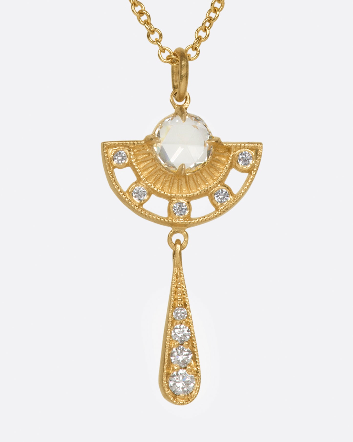 A rose cut diamond sit at the heart of this cutout drop pendant.