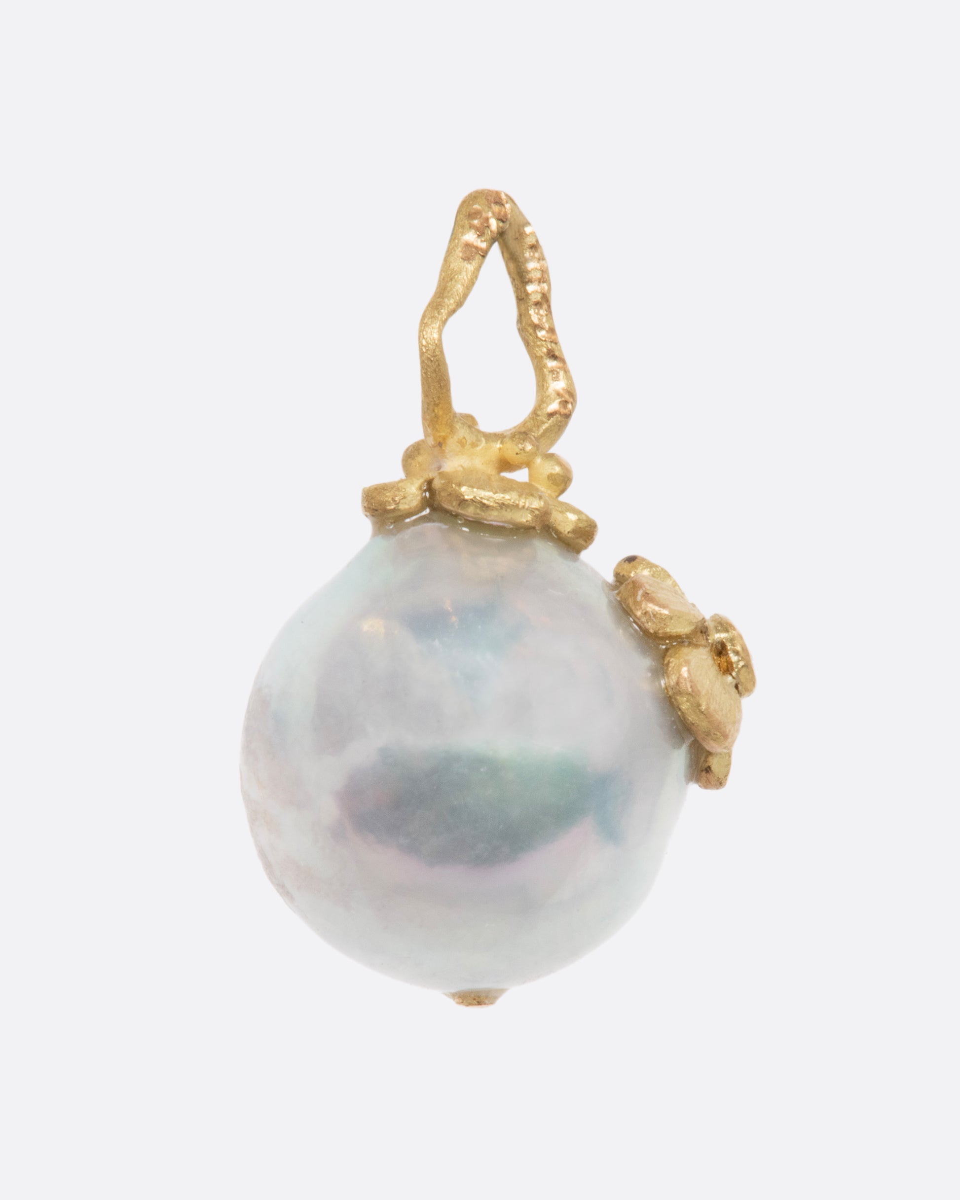 Pearl pendant with a yellow gold bale featuring two small flowers, one with a diamond center. View from the side.