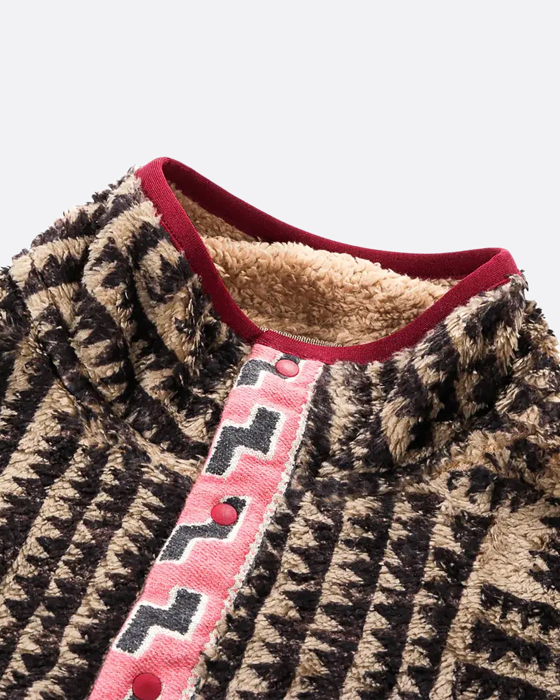 A brown a tan zig zag print fleece pullover with pink detail at the front closure. View from the front laying flat, close up.