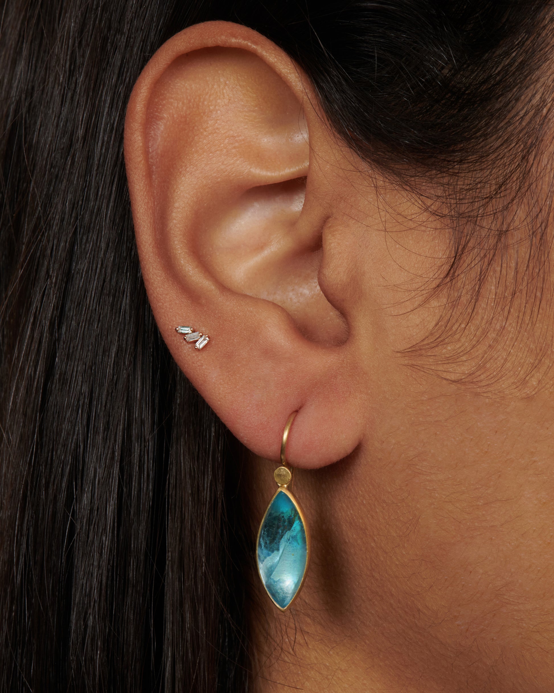 A pair of 18k gold dangling earrings with aquamarine navette drops. These elongated aquamarines contrast with any hair color, making them a versatile and gorgeous pop of color while wearing your hair up or down.