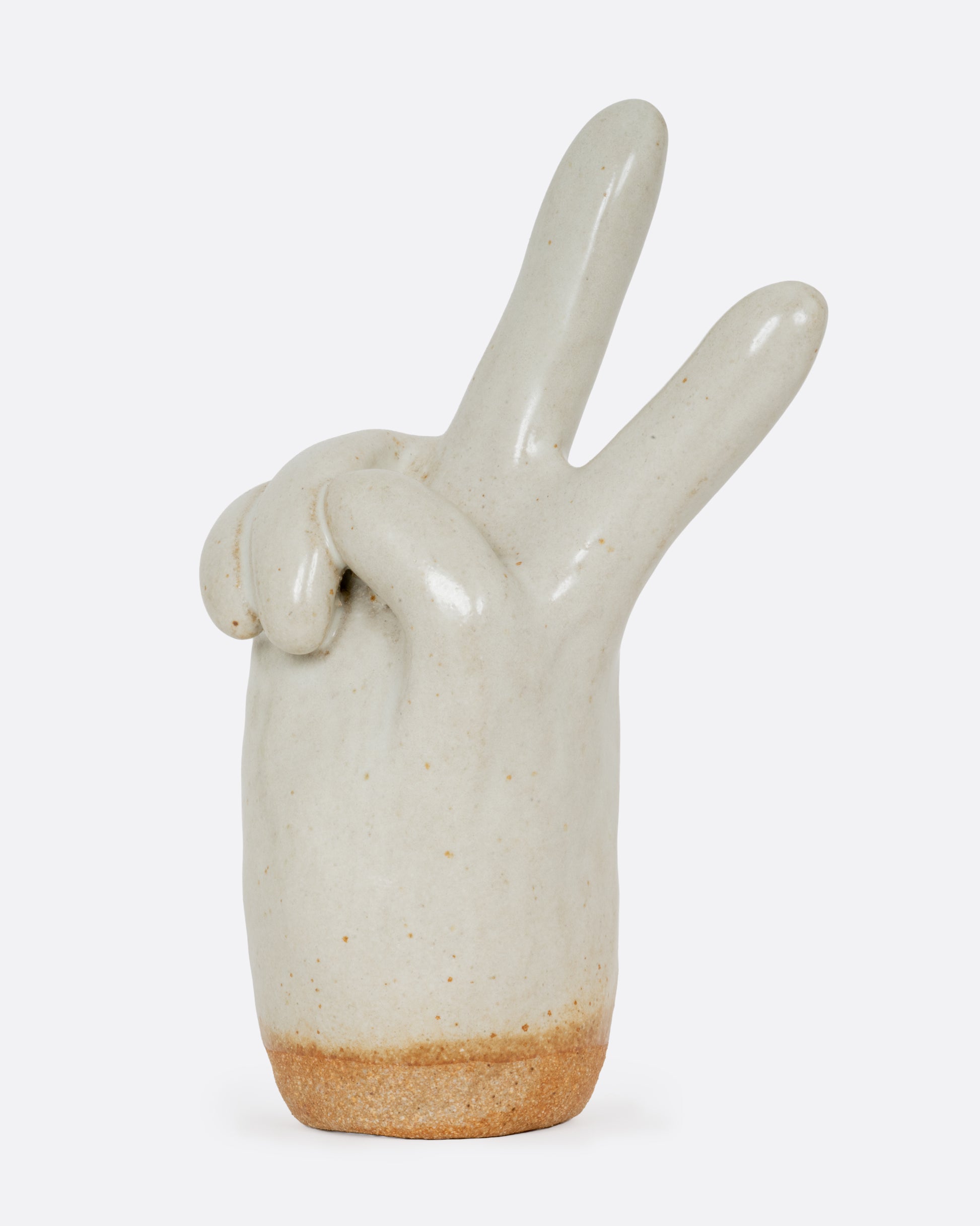 A stoneware white hand making the peace sign glazed in speckled white. Shown from the side.