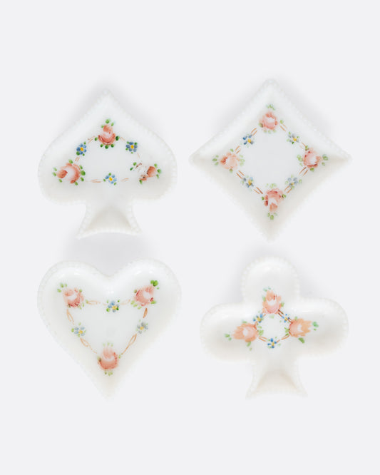 Four white ceramic dishes shaped like playing card suits with  floral designs. Shown from the top.