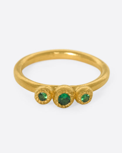 Yellow gold green garnet three stone ring, front view of the three garnets