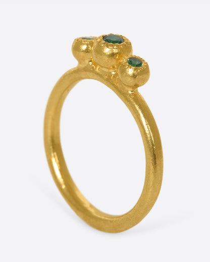 Yellow gold green garnet three stone ring, angled view showing the height of the three bezels