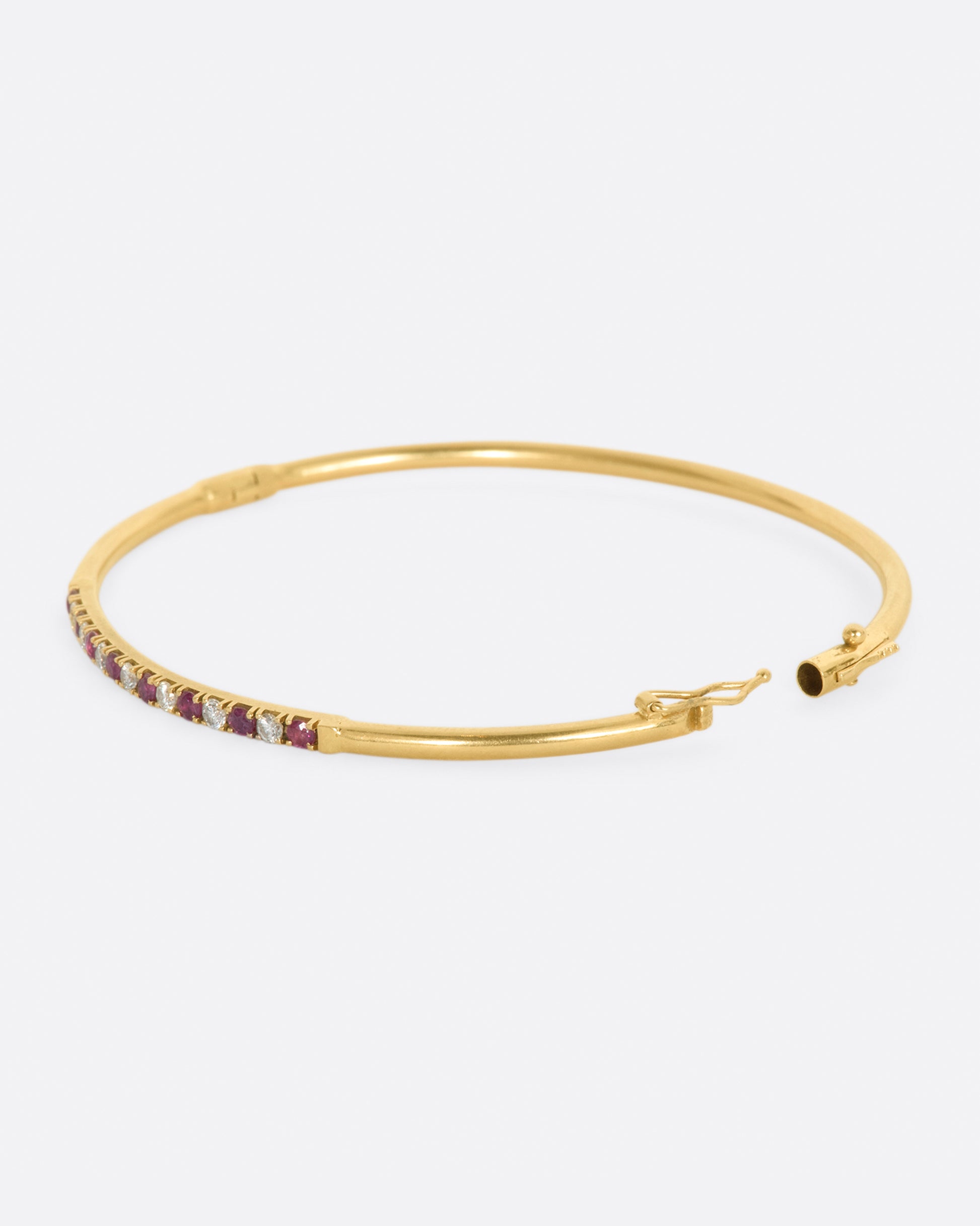 Yellow gold bracelet with alternating rubies and diamonds. View from the left side, opened.