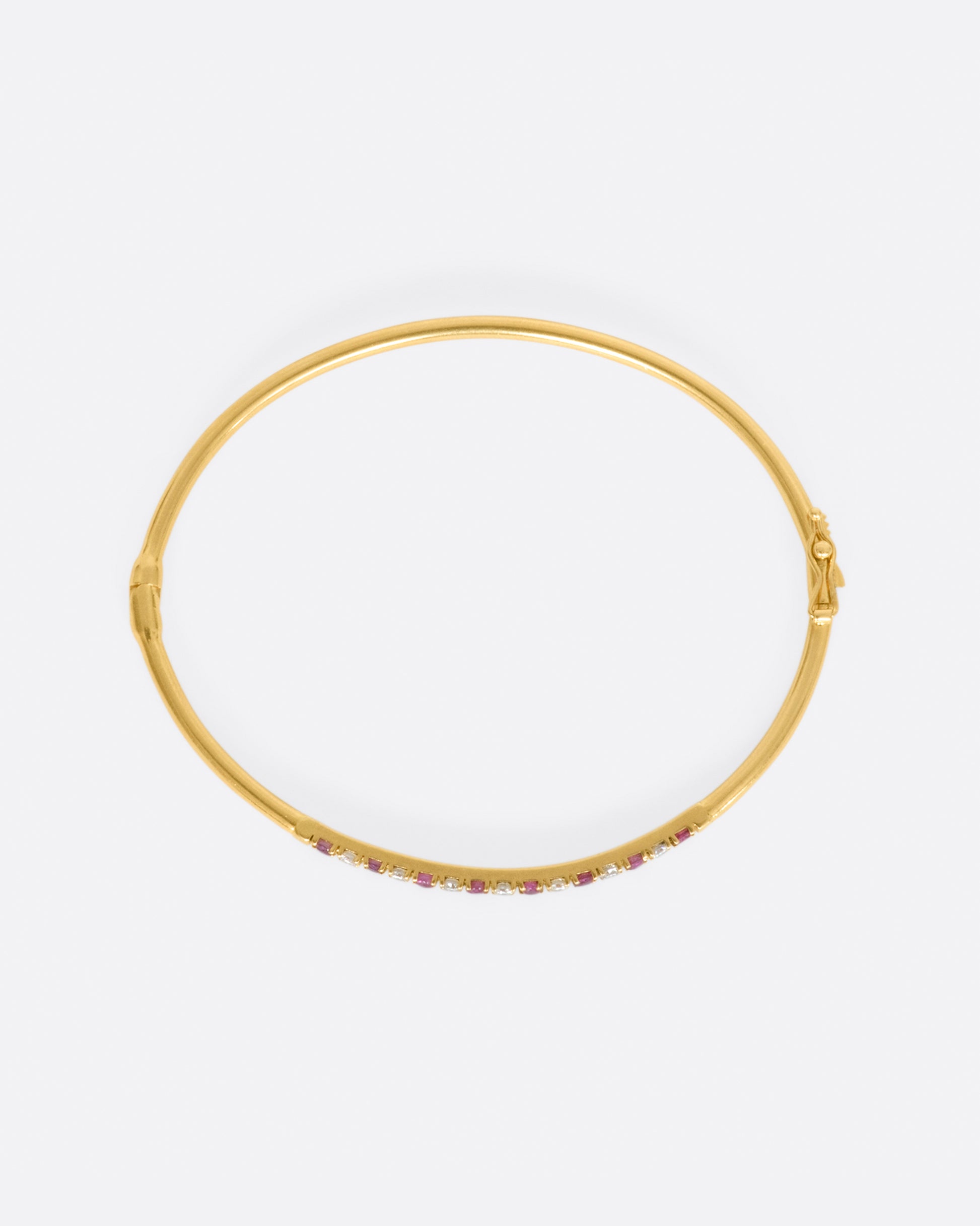 Yellow gold bracelet with alternating rubies and diamonds. View from above.