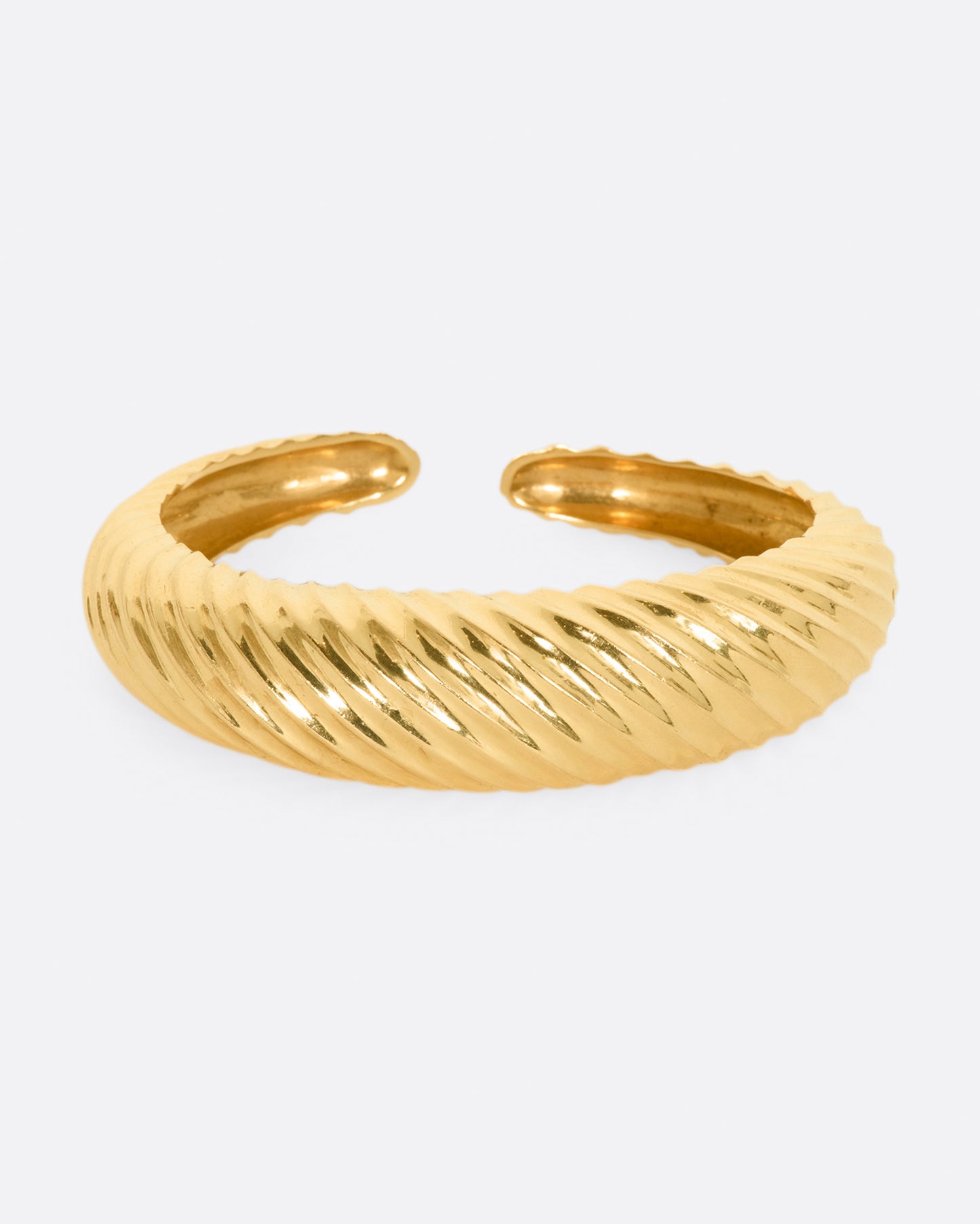 Yellow gold cuff with ridges that create a twisted look. View from the front.