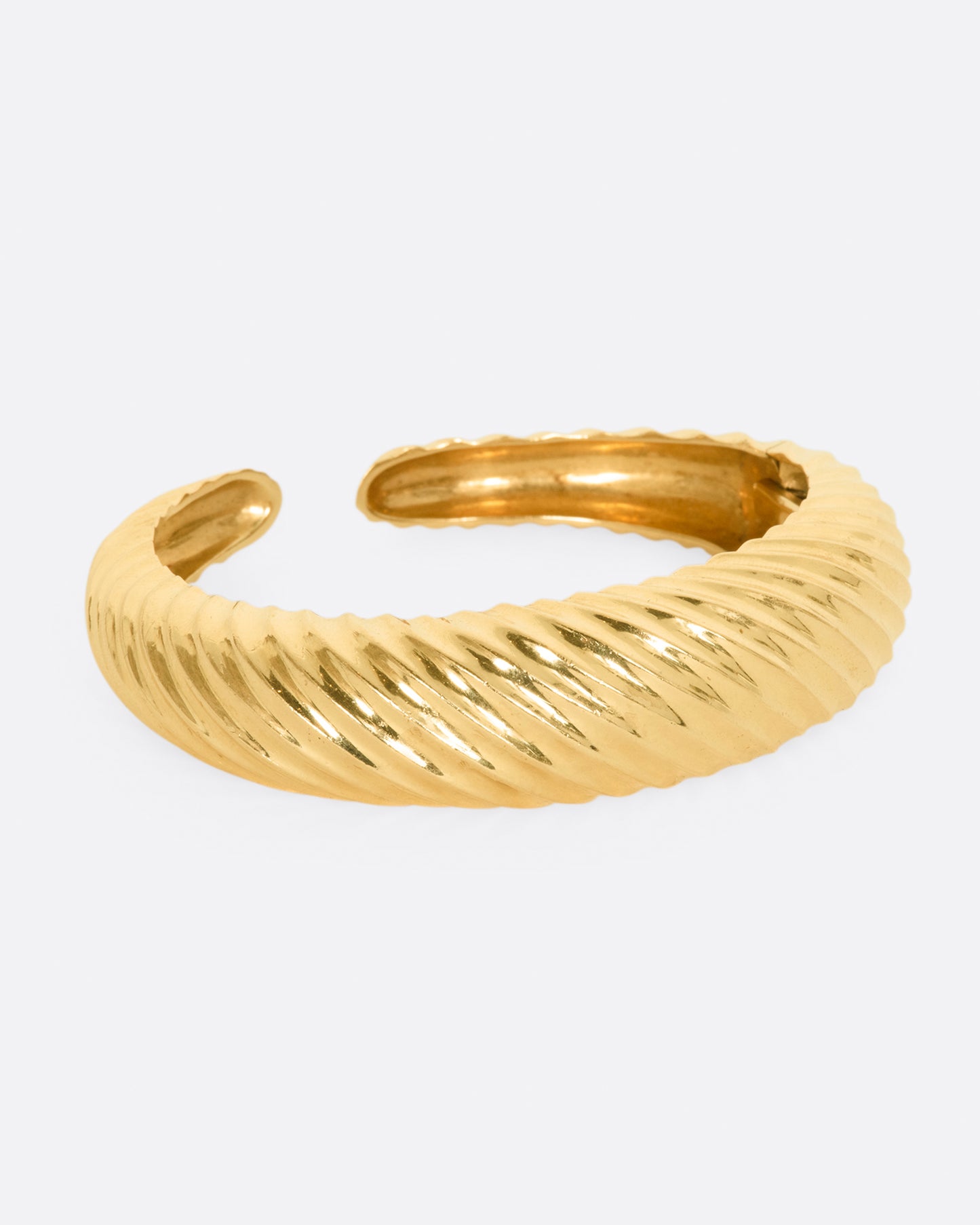 Yellow gold cuff with ridges that create a twisted look. View from the right side.