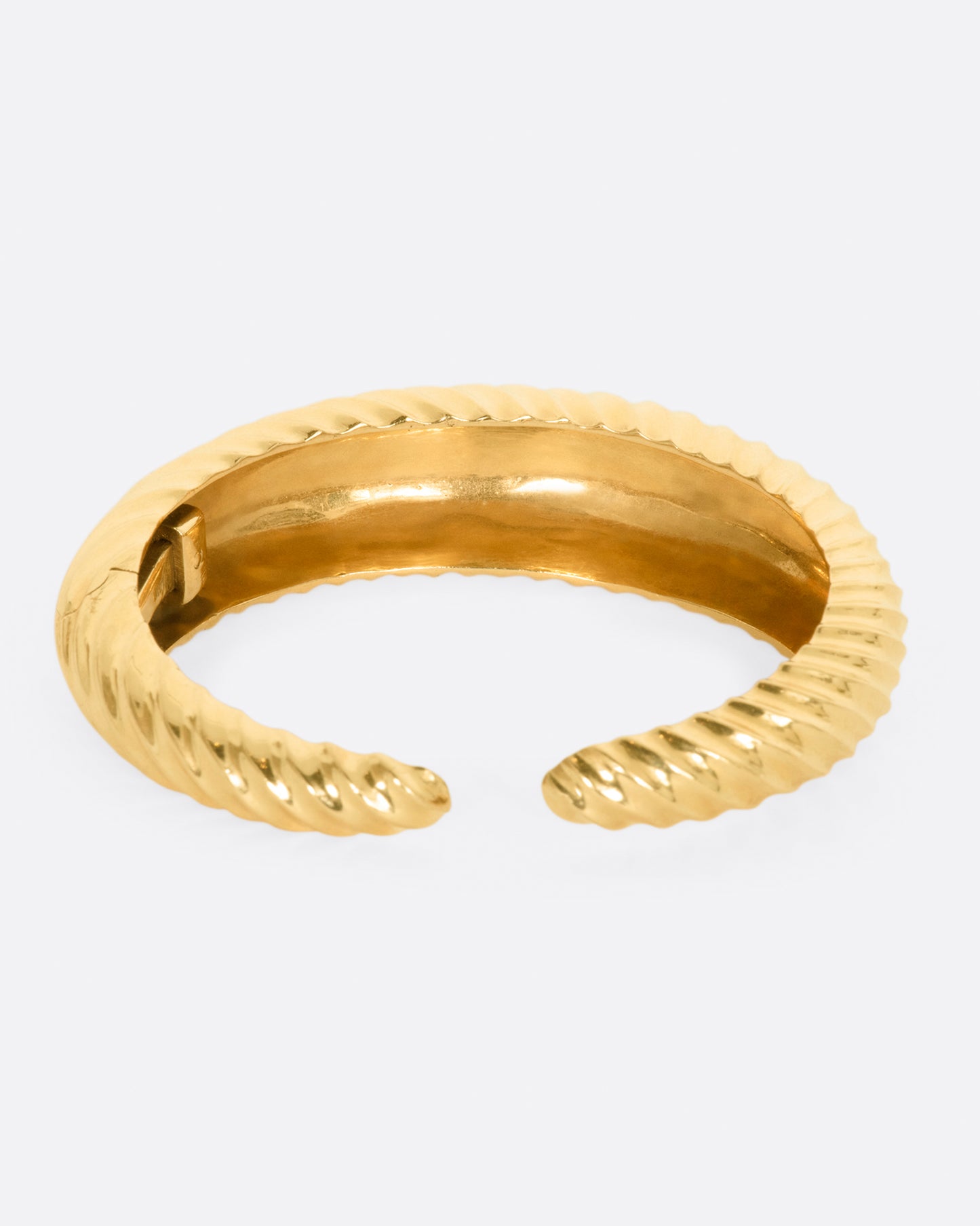 Yellow gold cuff with ridges that create a twisted look. View from the back.