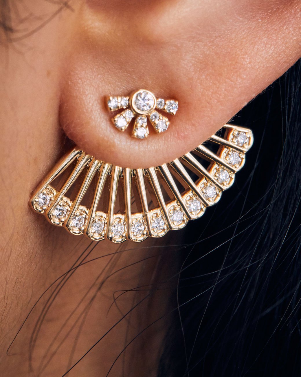 womans ear with the ear jacket attached and a stud earring in the front