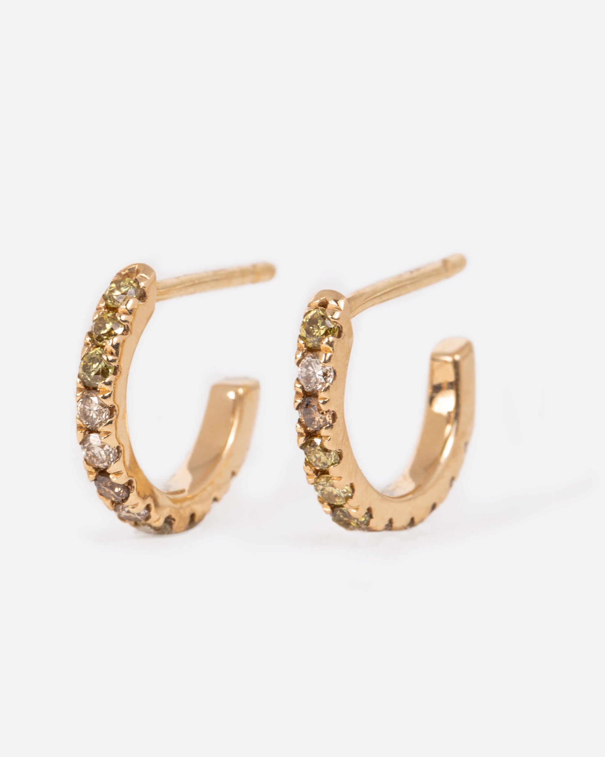 A pair of yellow gold hoops lined with shades of olive, champagne and cognac diamonds.