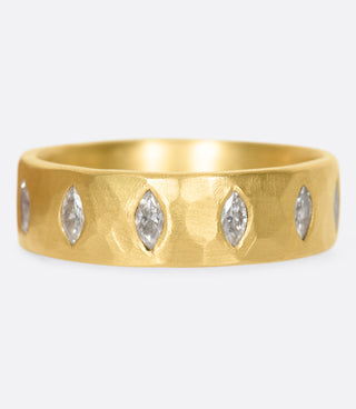 A wide, hammered, matte gold ring with marquise diamonds set all the way around.