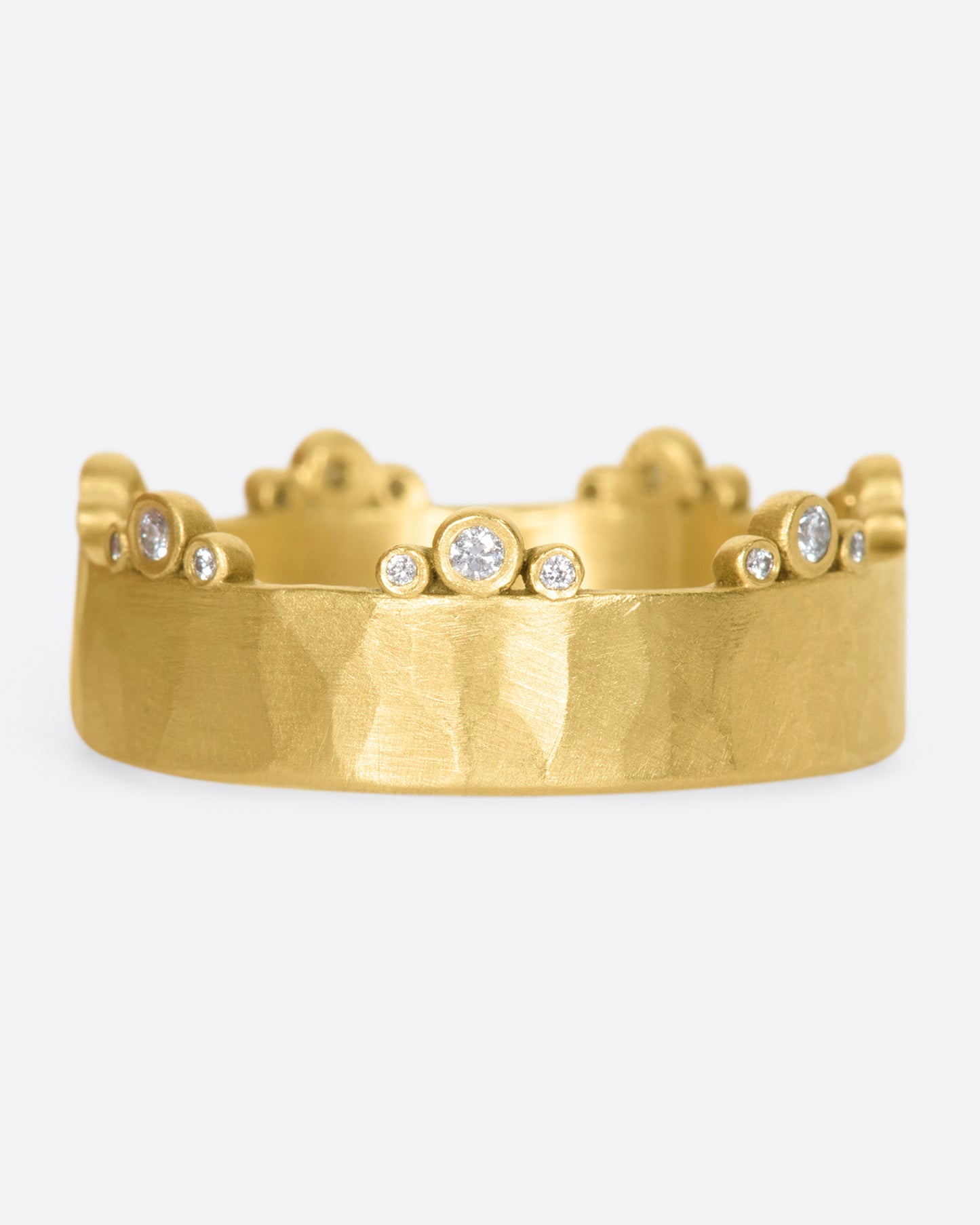 A wide, hammered, matte gold band with stations of diamonds along one edge.