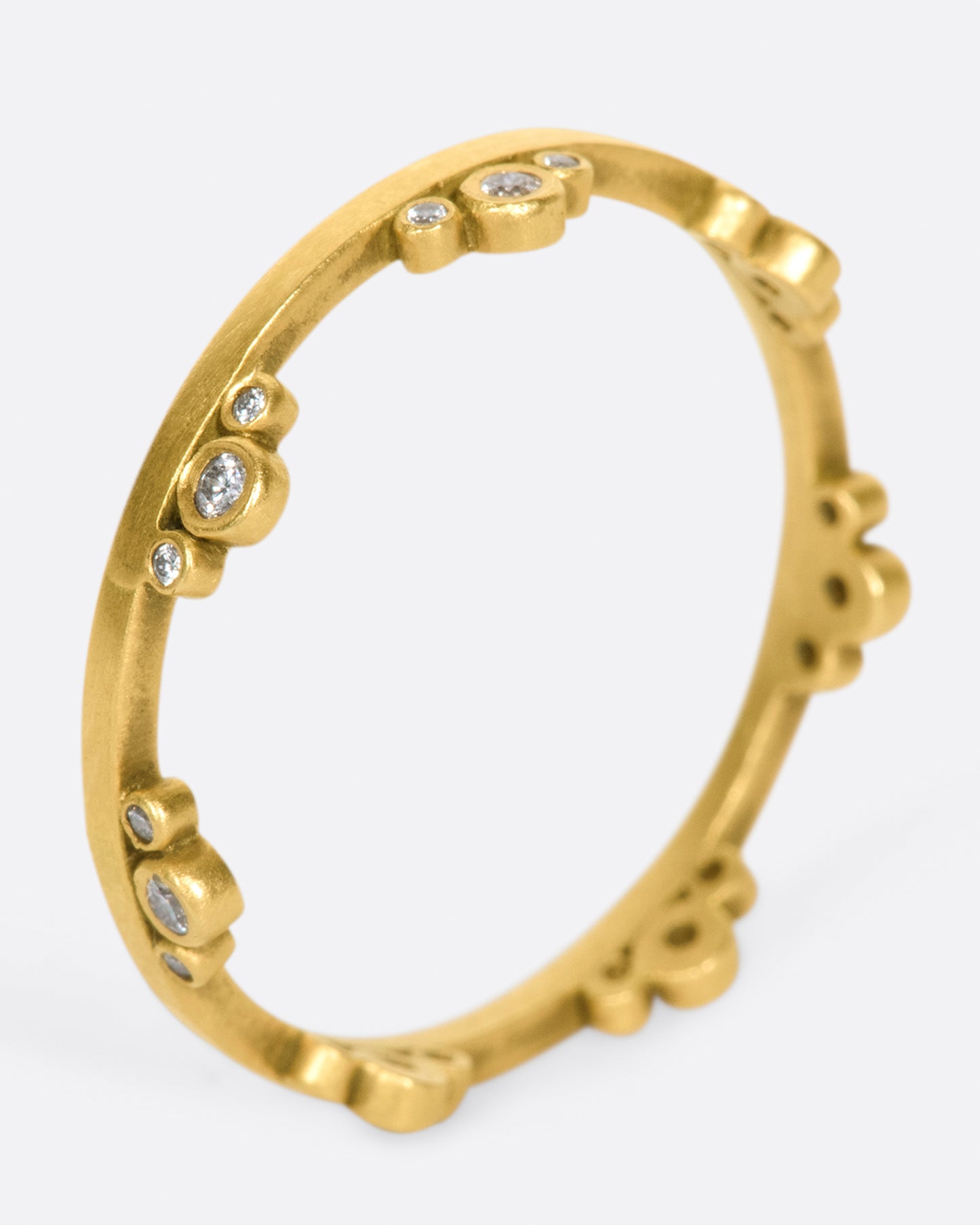 A matte gold band crowned with seven trios of diamonds.