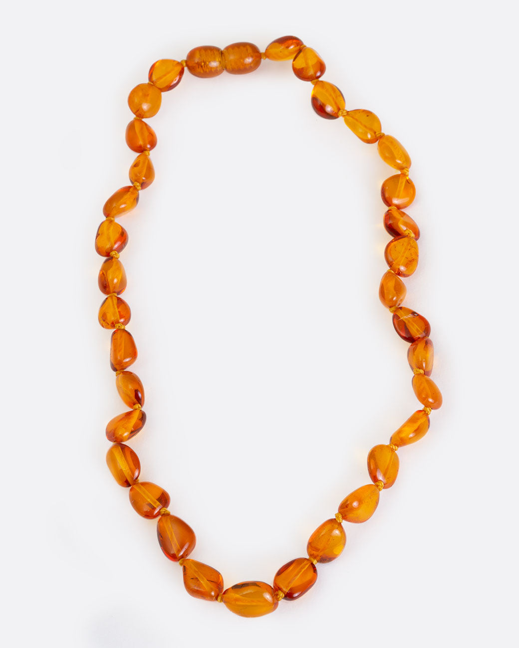 Cognac amber teething necklace, shown laying flat.