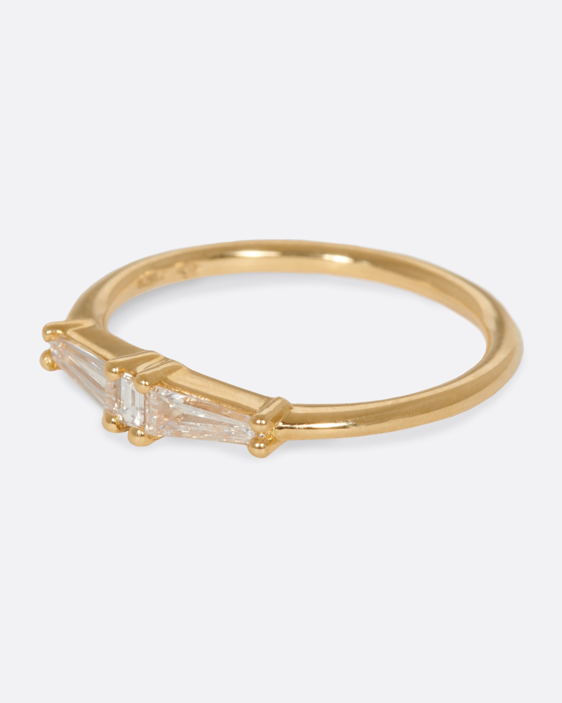 A ring featuring two tapered baguette diamonds and one carre cut diamond; perfect for stacking.