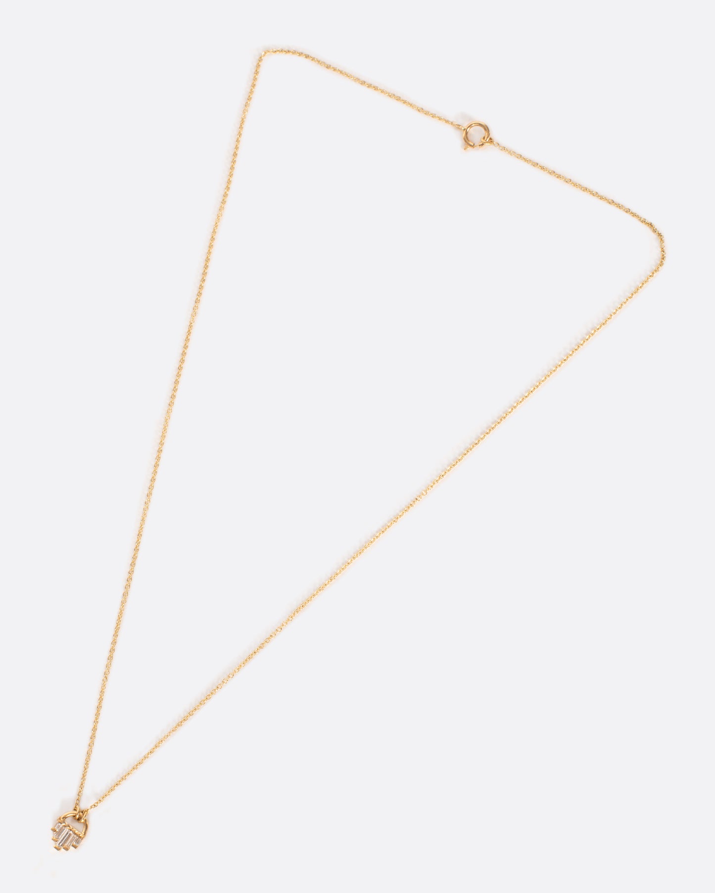 A curved gold pendant necklace with five diamond baguettes.