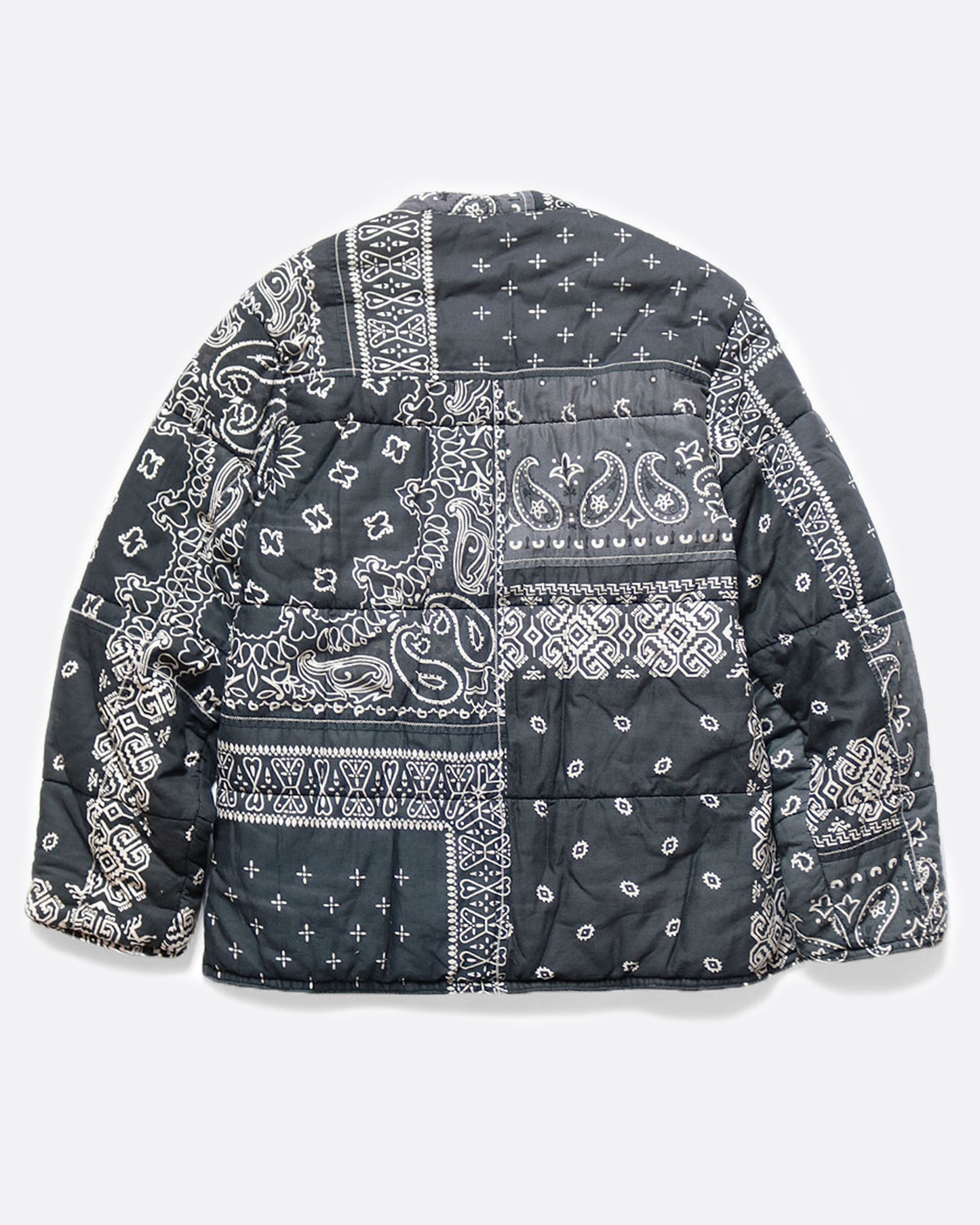 A button down quilted patchwork bandana jacket, shown laying flat on its back side in the black colorway.
