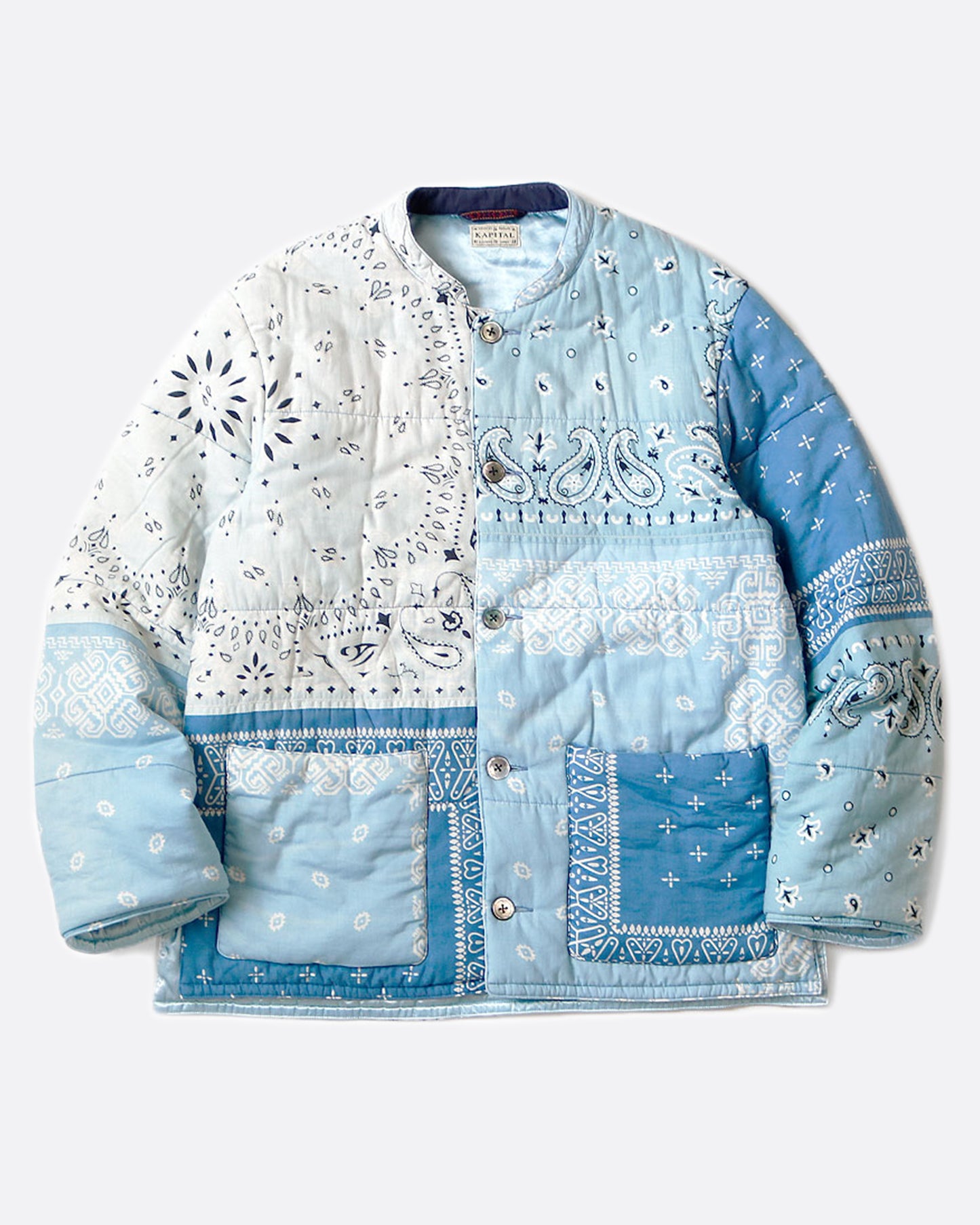 A button down quilted patchwork bandana jacket, shown laying flat in the light blue colorway.