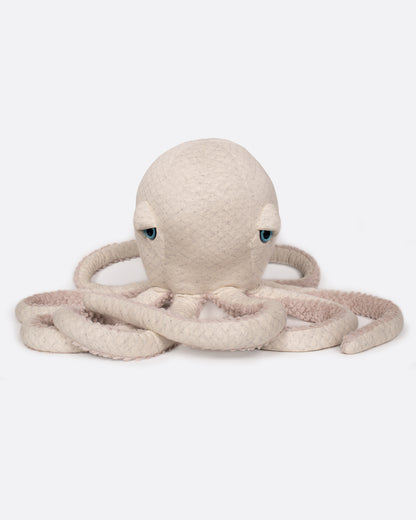 A stuffed plush oatmeal colored octopus with blue eyes and a fuzzy belly. Shown sitting up from the front.
