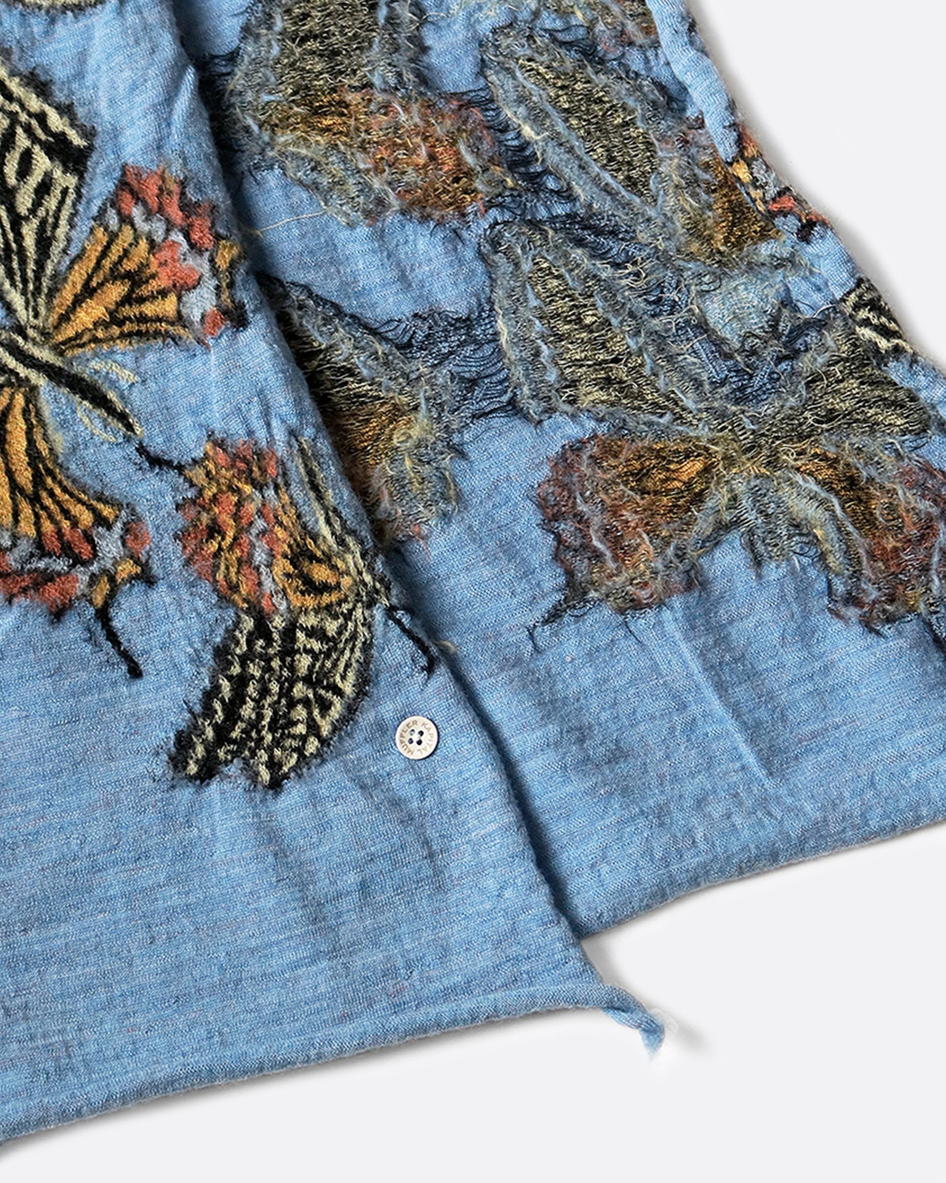 A sky blue scarf with butterflies on it.