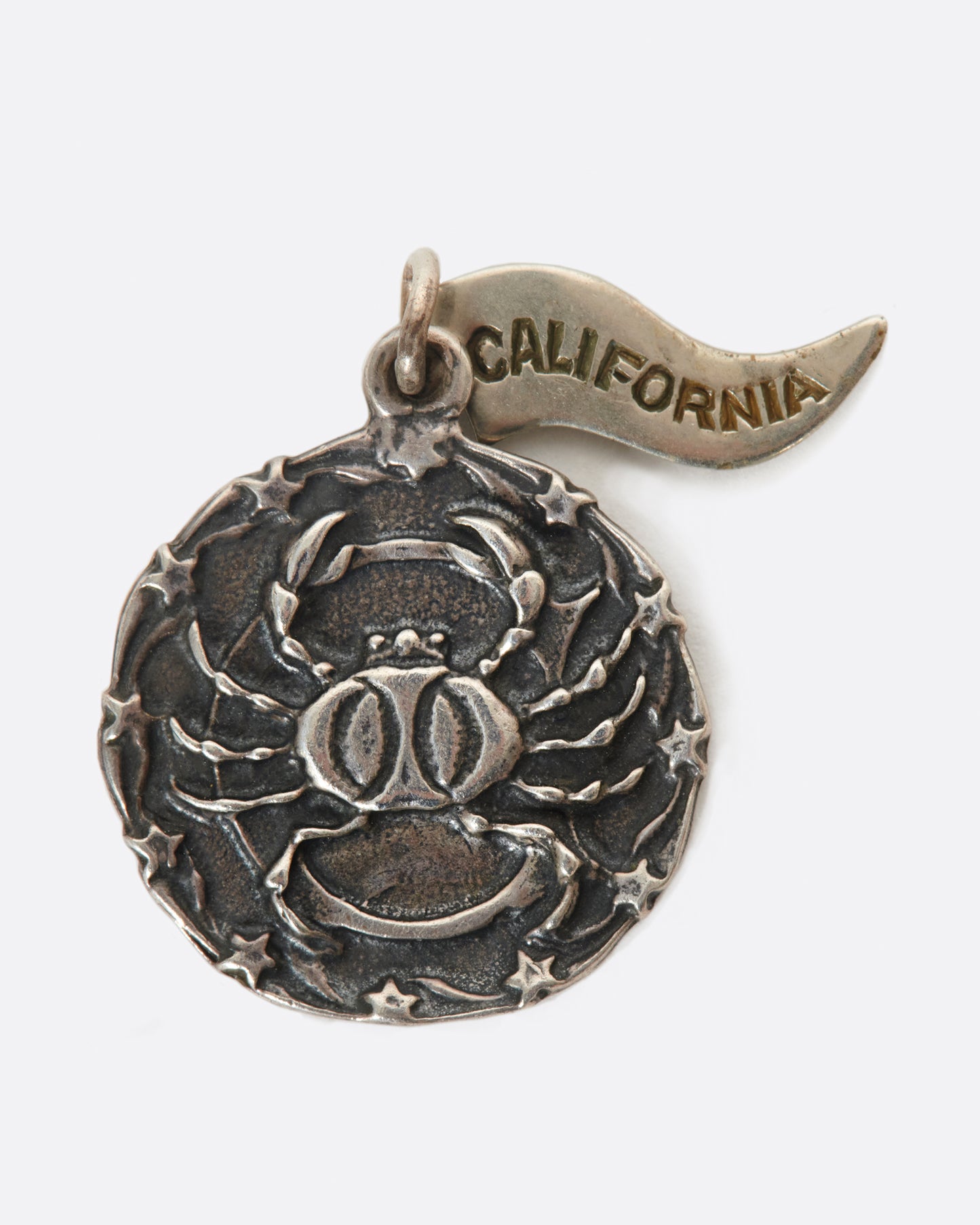 A round medal pendant with your zodiac sign and a California pennant.