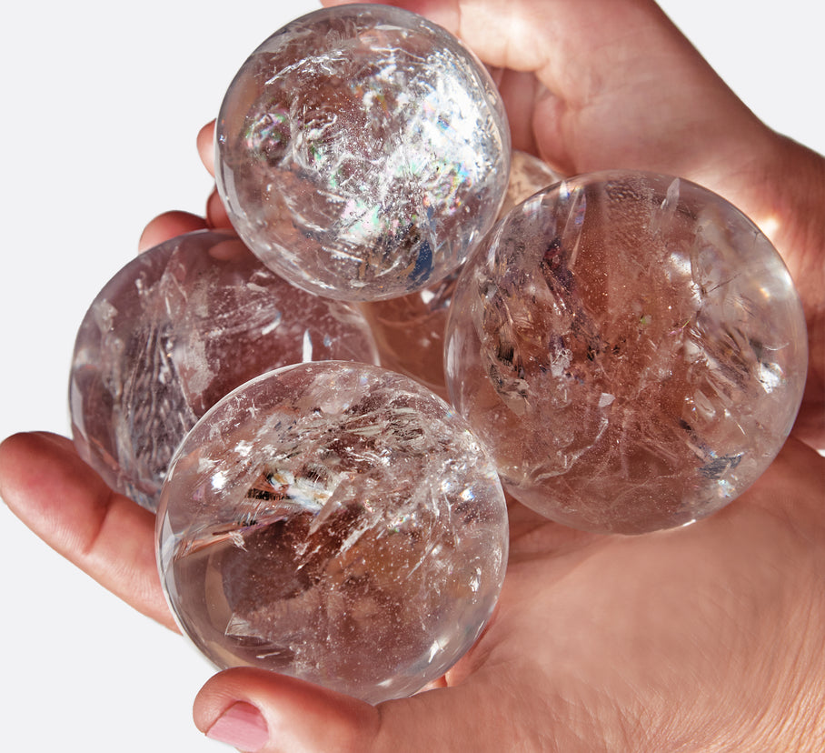 A group of lemurian quartz spheres in hands.