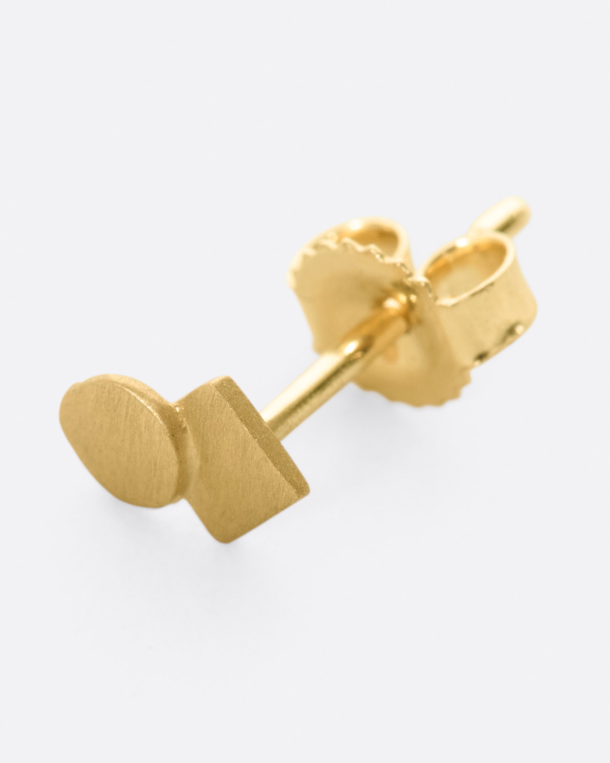 A yellow gold square stud earring with overlapping circle and matte finish.