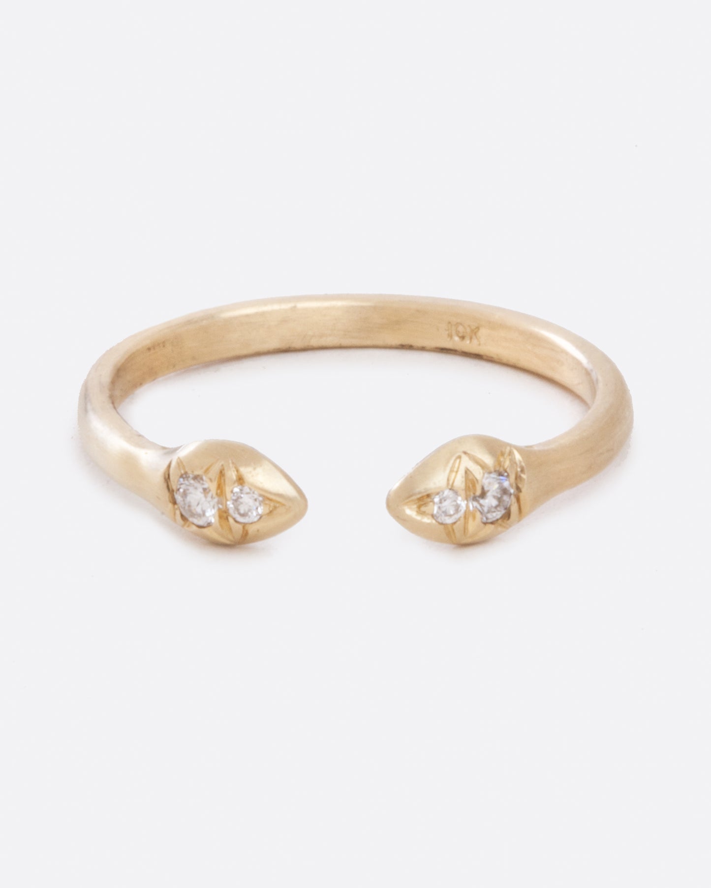 an open yellow gold ring from the front. the ends of the opening each have two diamonds set into it and is slightly bulbous.