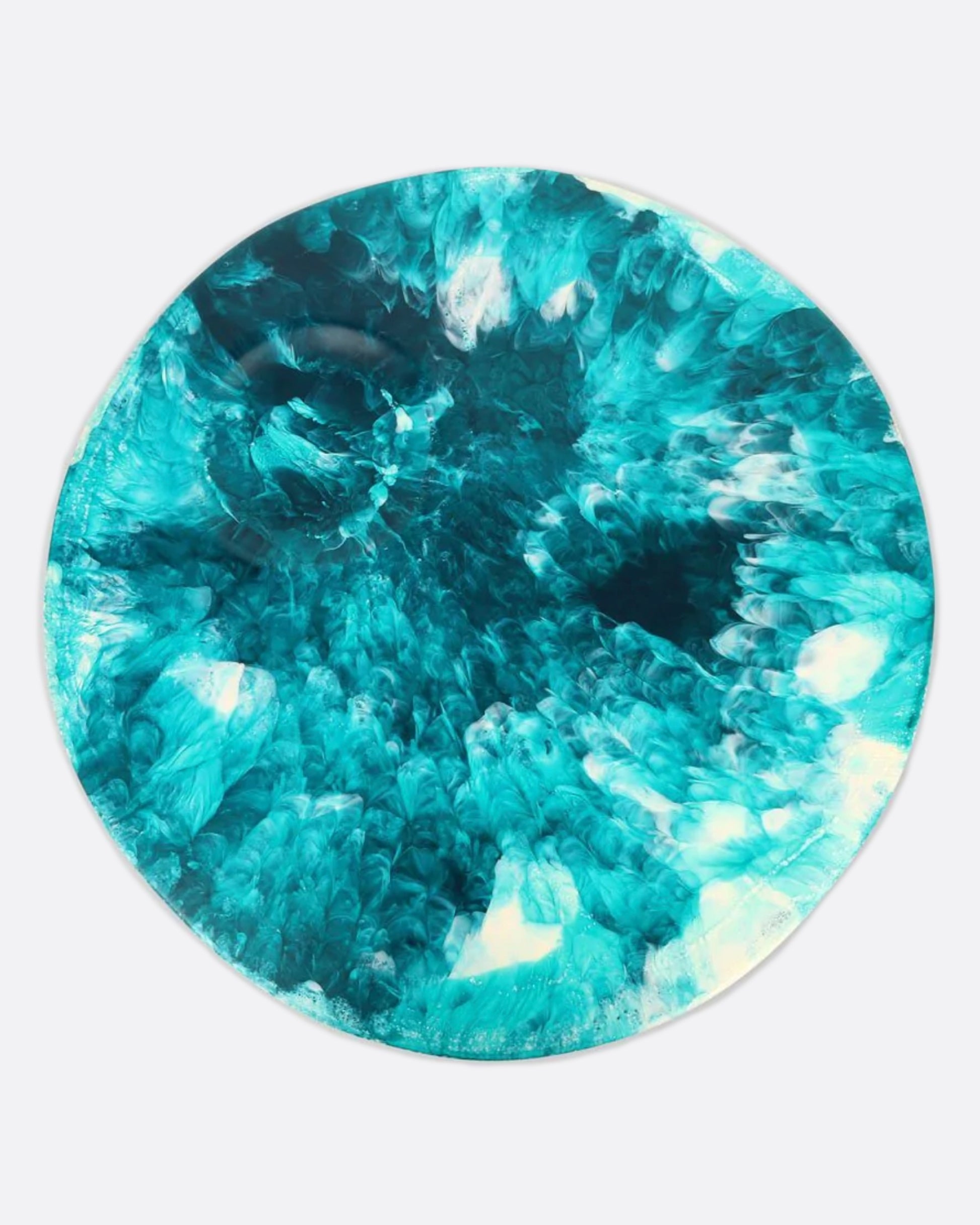 A round teal blue and white resin platter with a round indentation, shown from above.