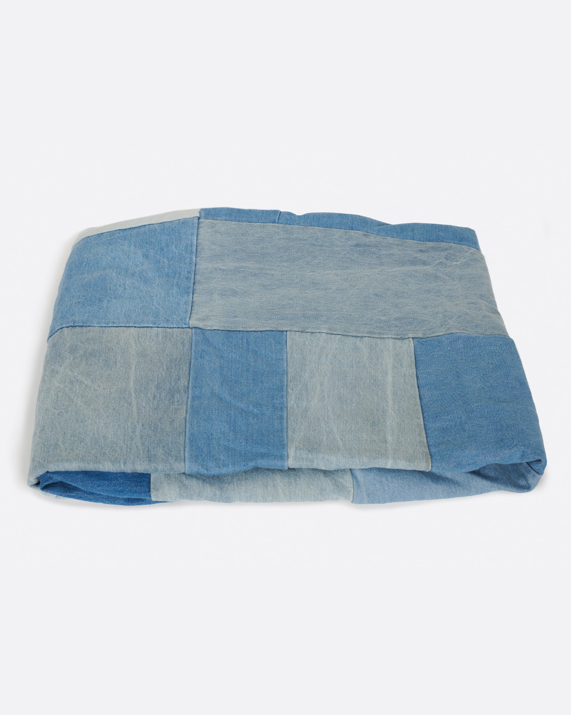 A handcrafted blanket made from pieces of dead stock denim, perfect for picnics.