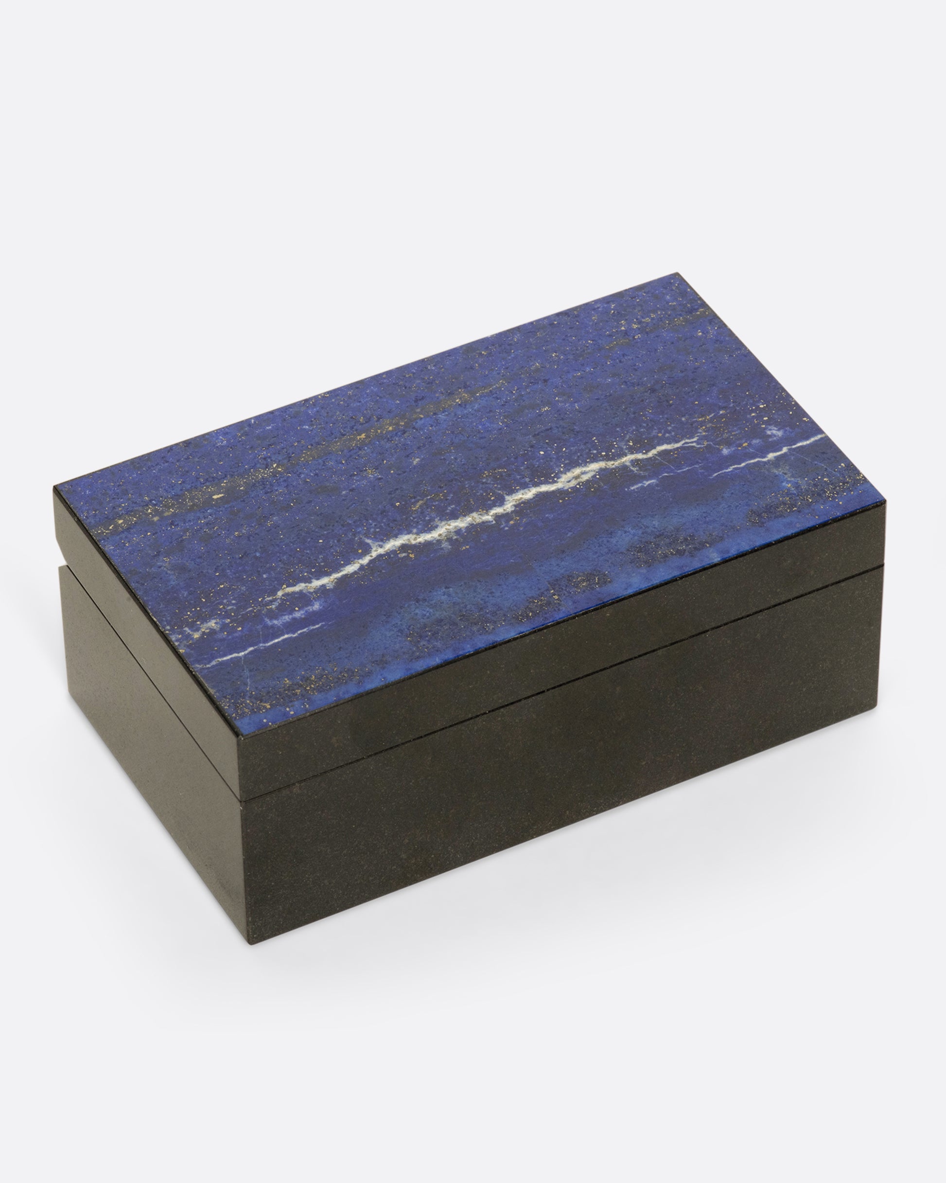 A hinged box made from dark igneous rock with a deep blue layer of lapis on the lid.