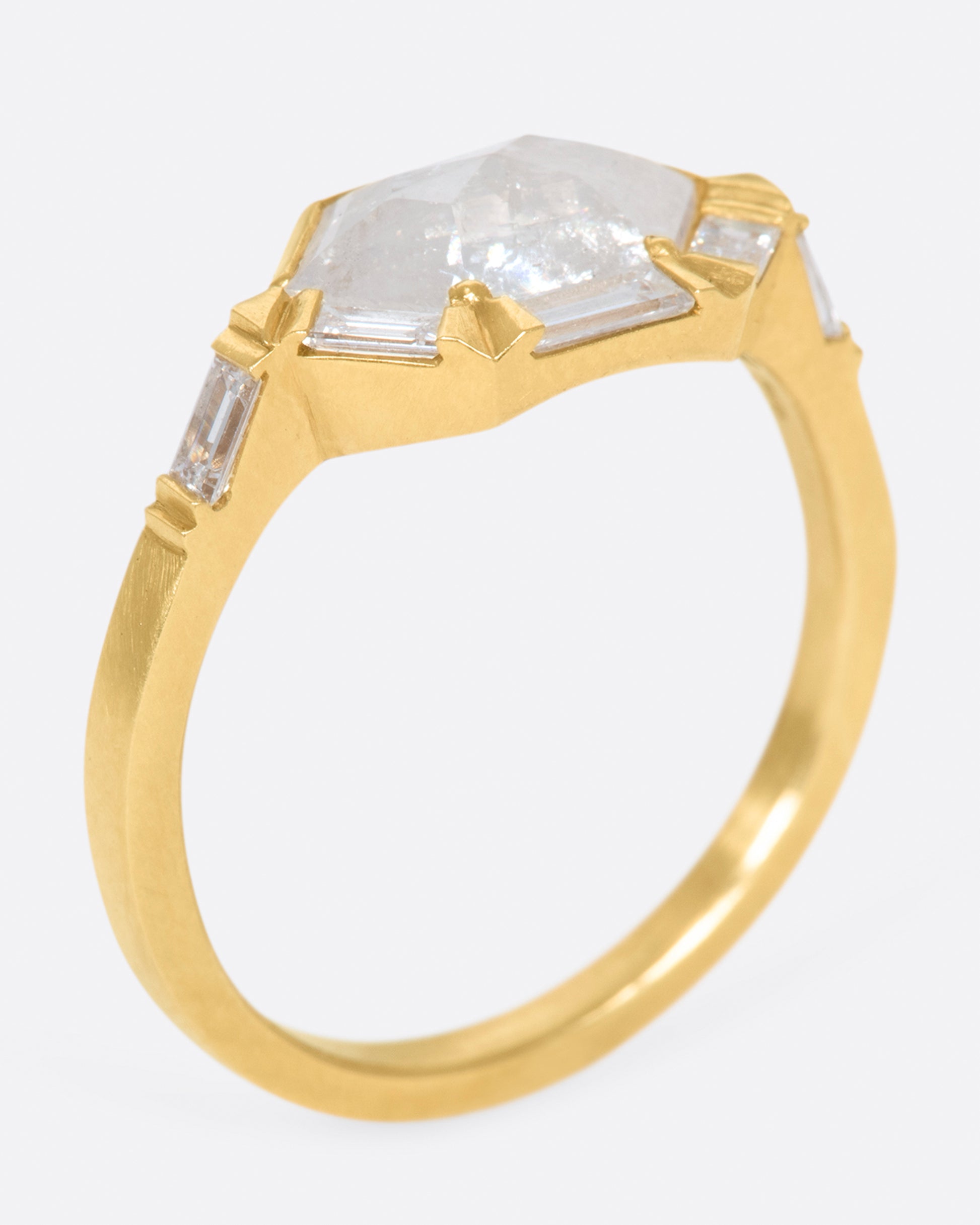 This ring features an east-west set, hexagonal, rose cut gray diamond with a half-halo of baguette diamonds.