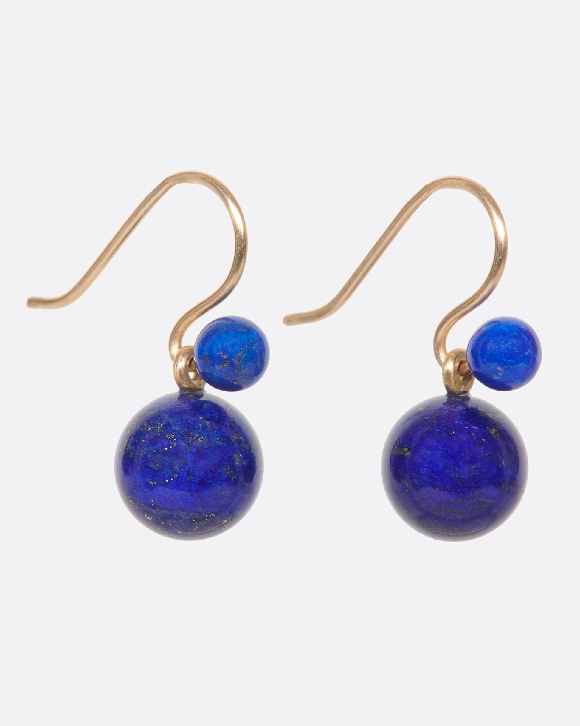 Two natural lapis spheres hang to create a contemporary geometric earring. Each pair is slightly different, as malachite has variations in its color naturally.