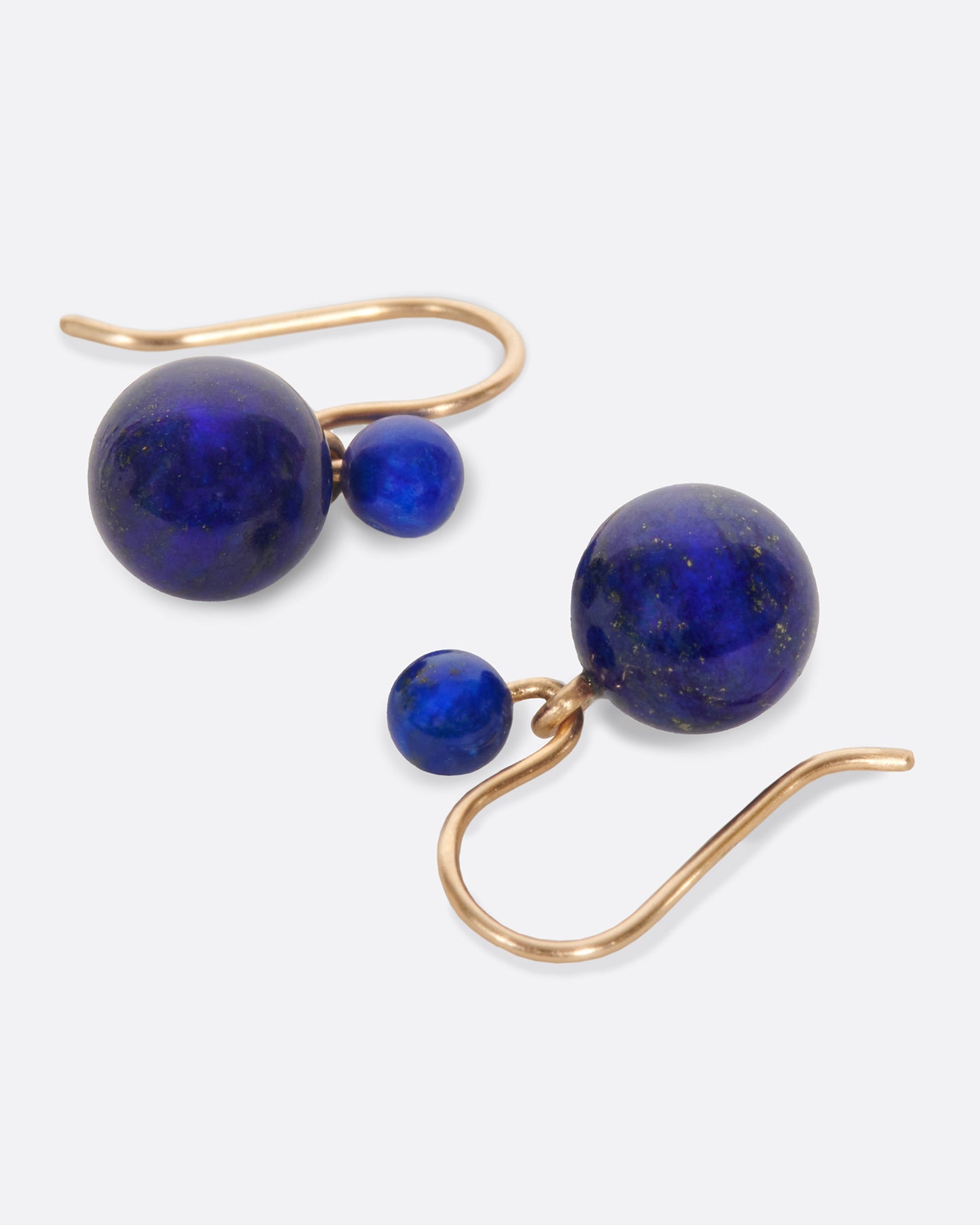 Two natural lapis spheres hang to create a contemporary geometric earring. Each pair is slightly different, as malachite has variations in its color naturally.