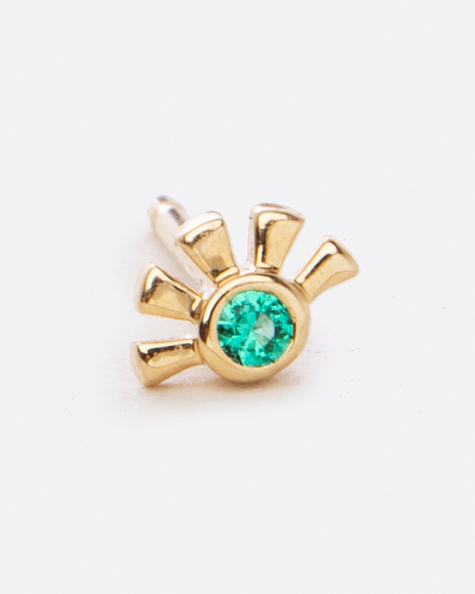 small yellow gold stud in the shape of a half sun with a small emerald in the middle