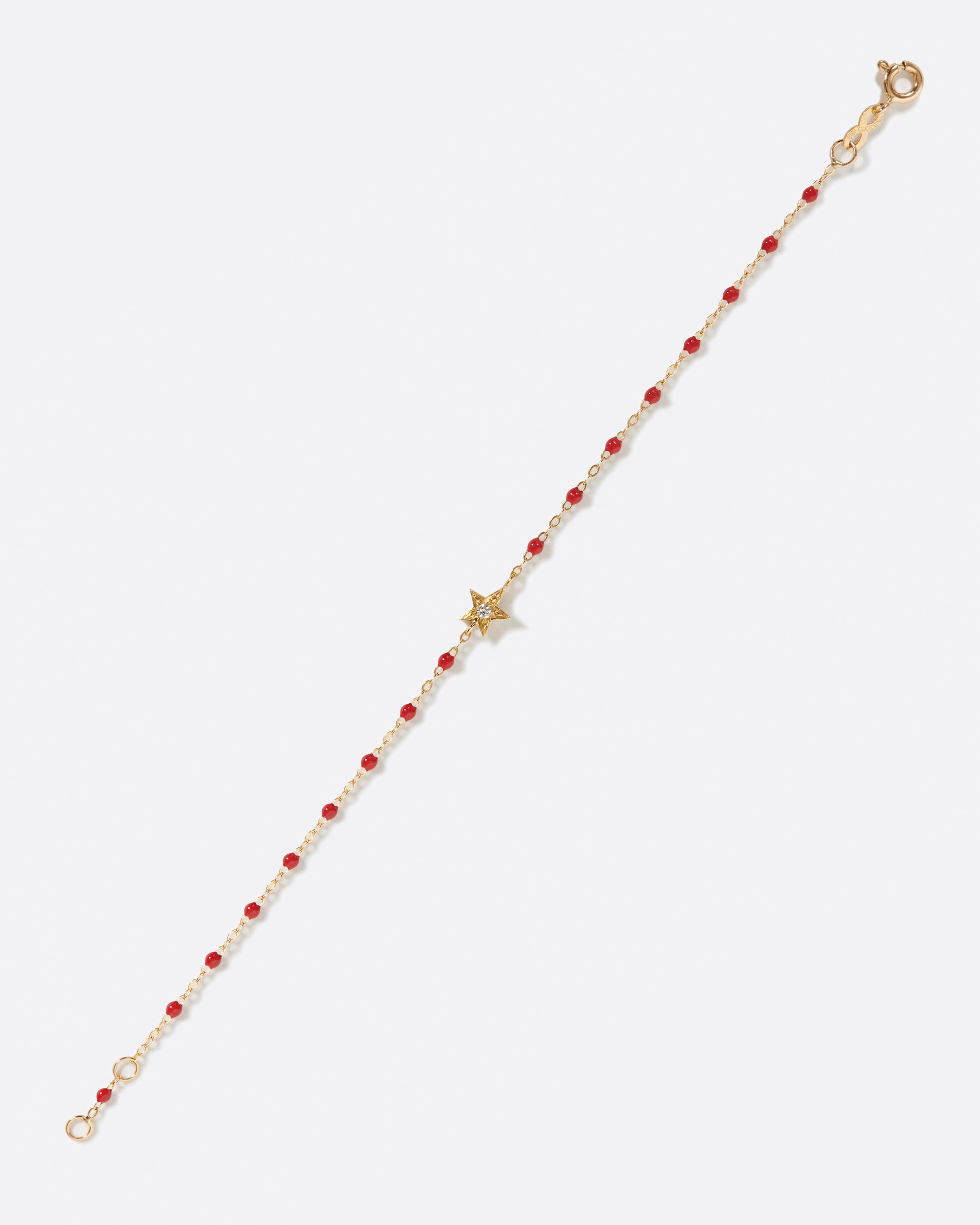 A classic Gigi Clozeau bracelet with poppy red resin and a five point star at its center.