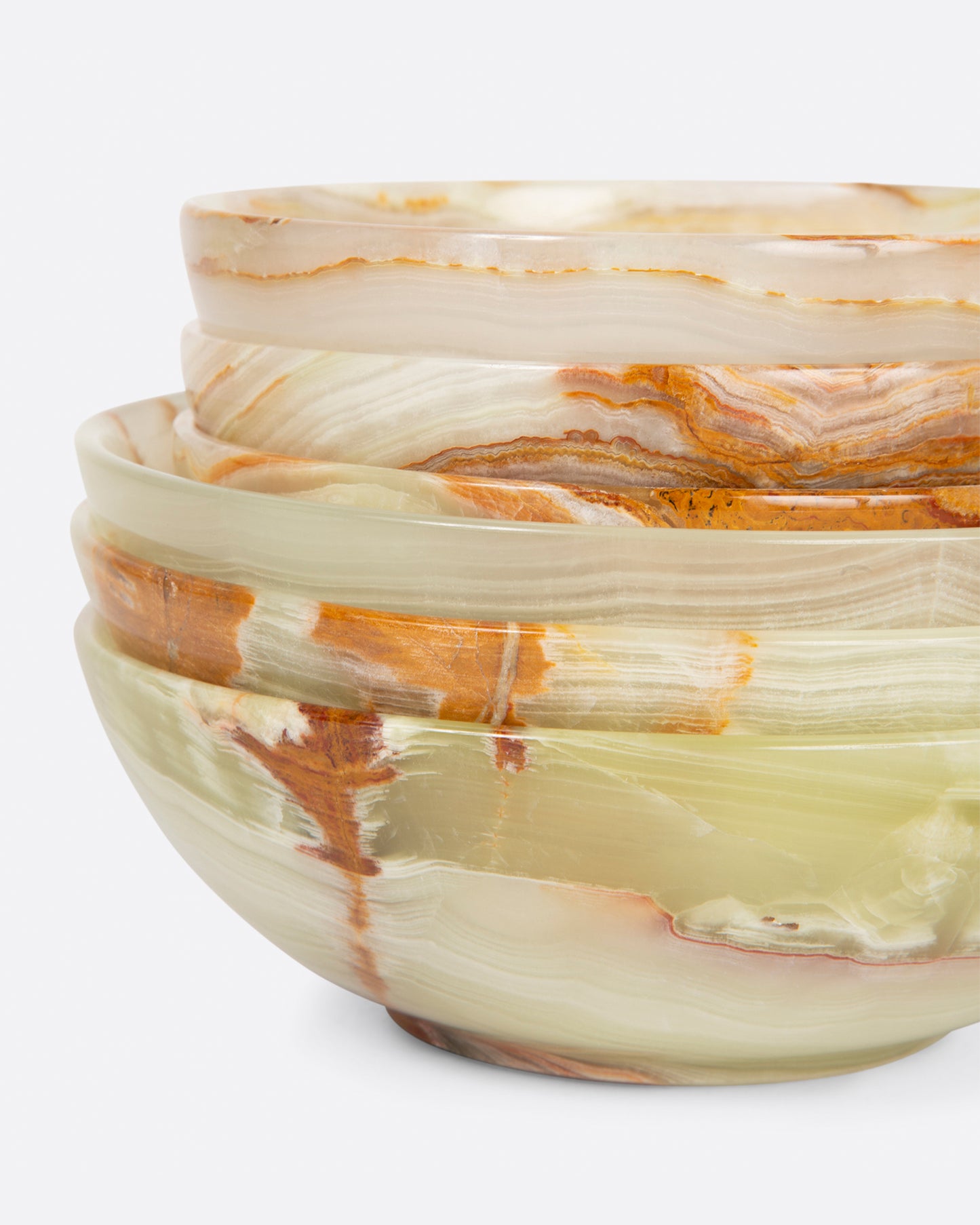 A stack of small and medium polished green onyx bowls shown from the side