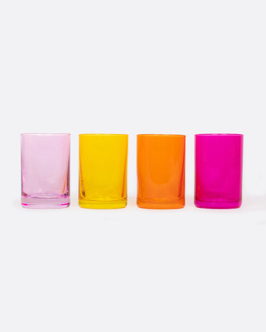 Four glass shot glasses in shades of pink, orange, and yellow.