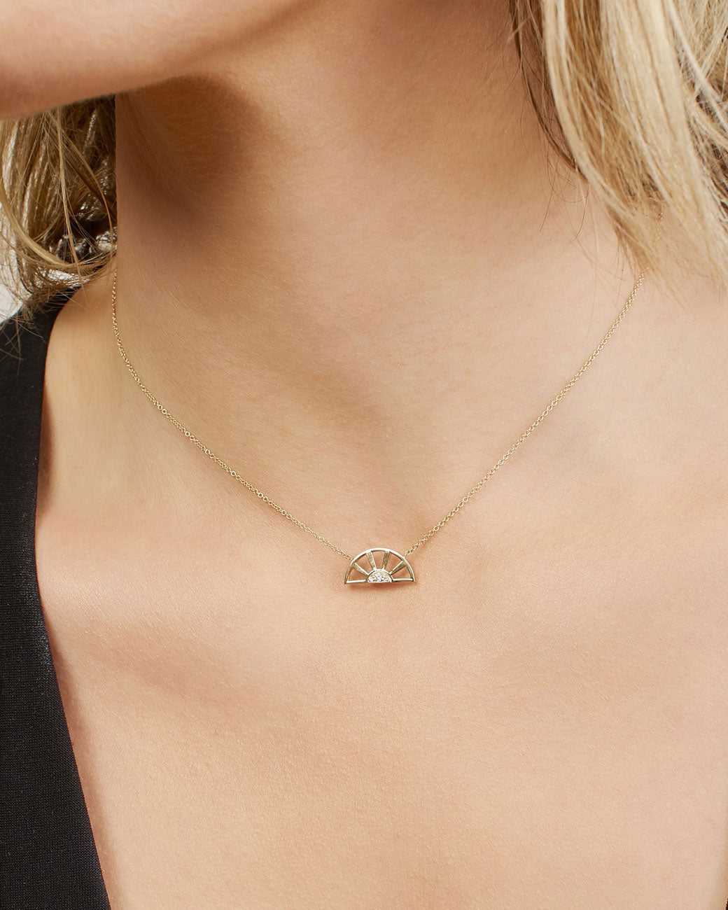 Designed to look like a sunset, this pendant necklace features three white diamonds set at the center of a yellow gold sun.