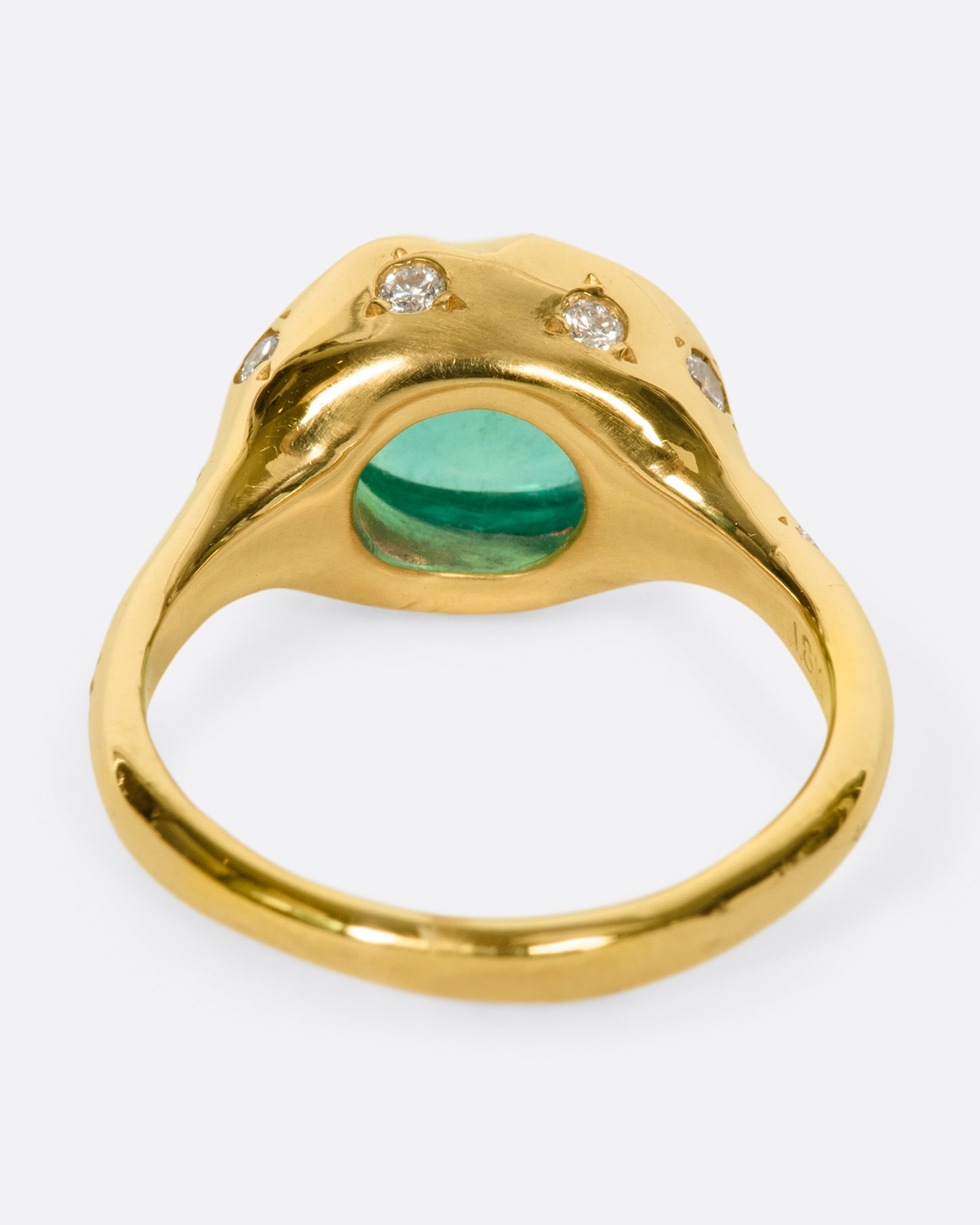 A bright green emerald cabochon sits at the center of this signet style ring.