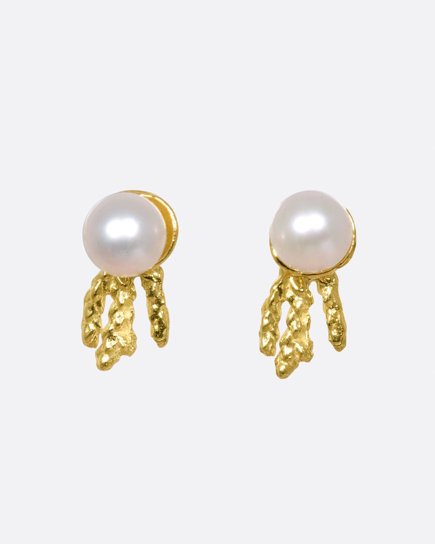 A pair of comet-like studs with Akoya pearls and gold trails.