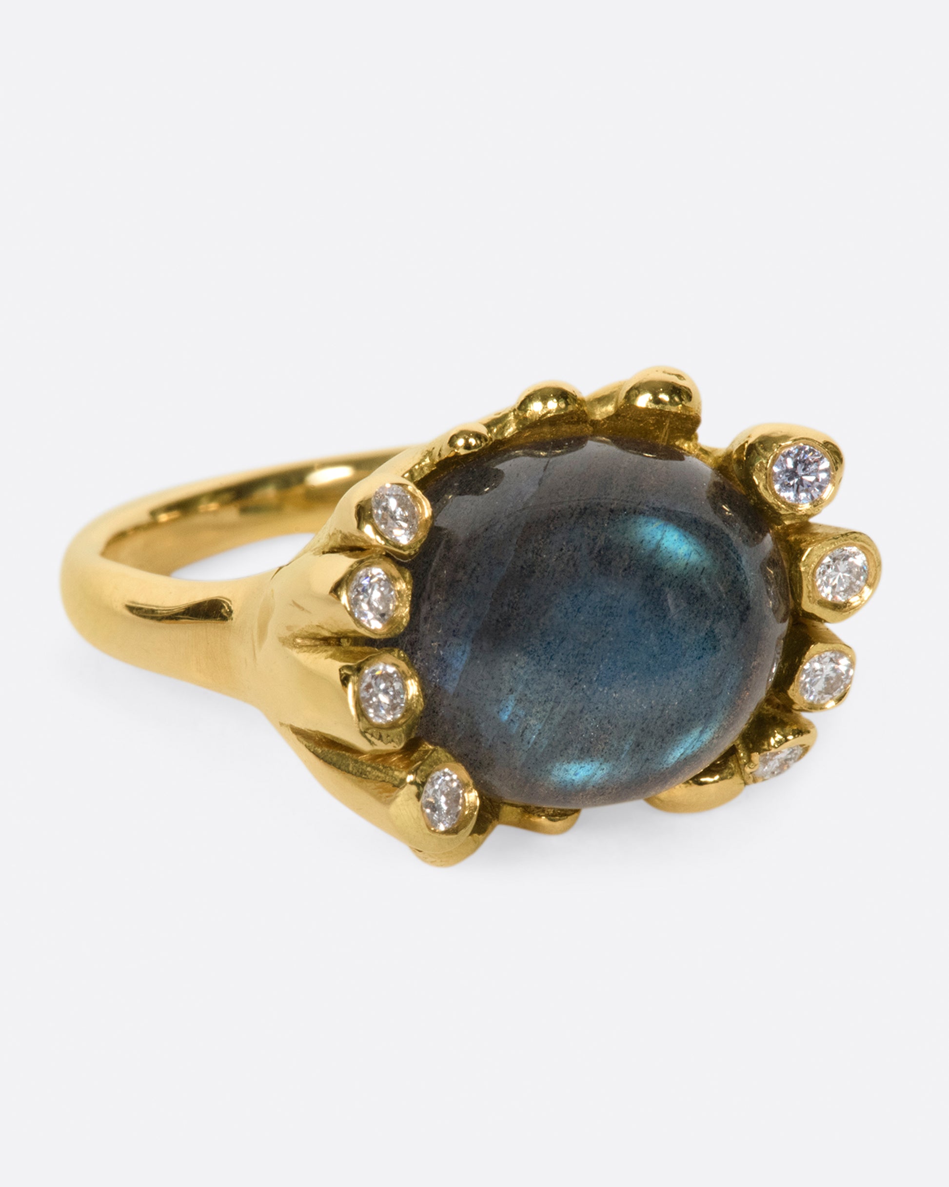 An iridescent labradorite cabochon is nestled amongst diamonds in its handcrafted setting.
